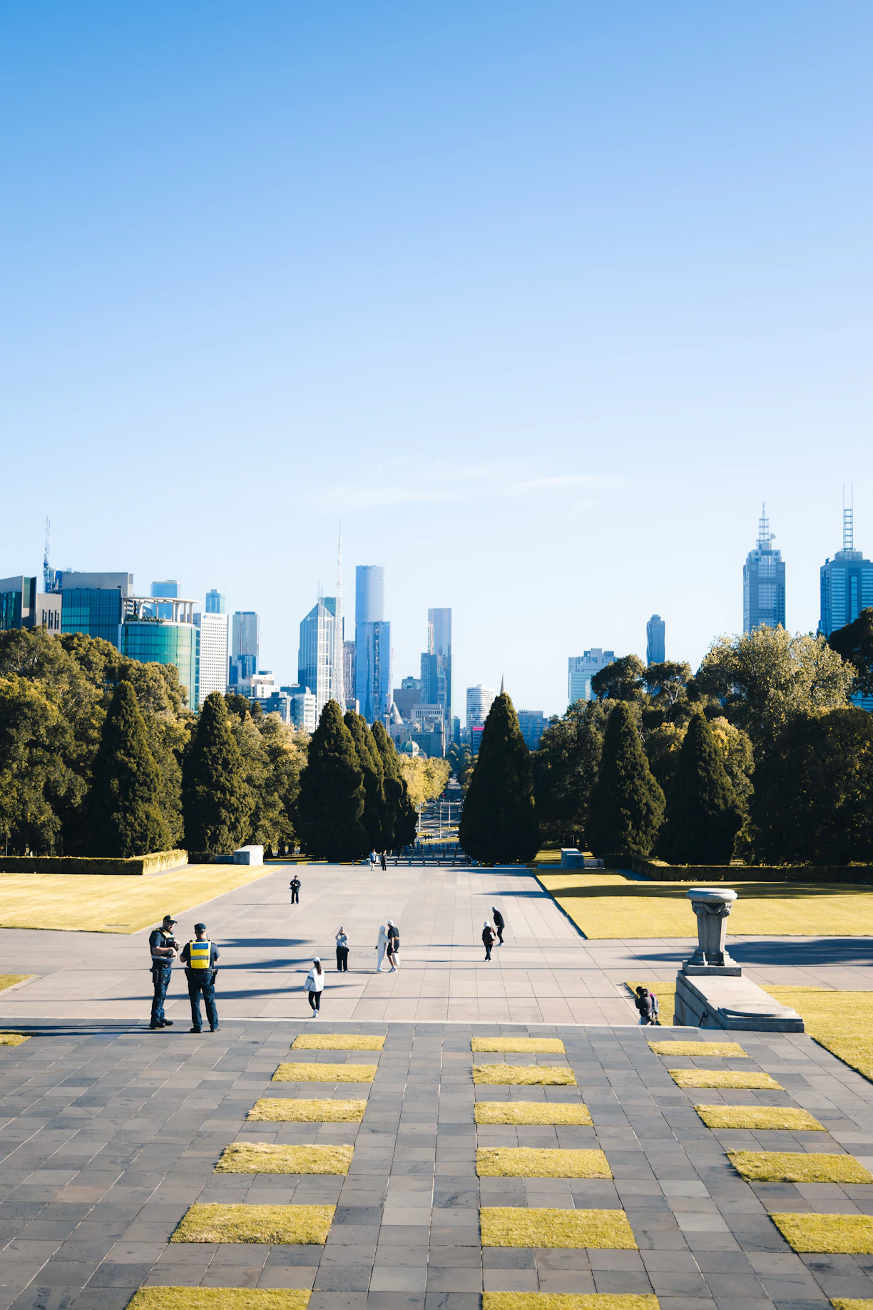 People walk on steps towards a city skyline.