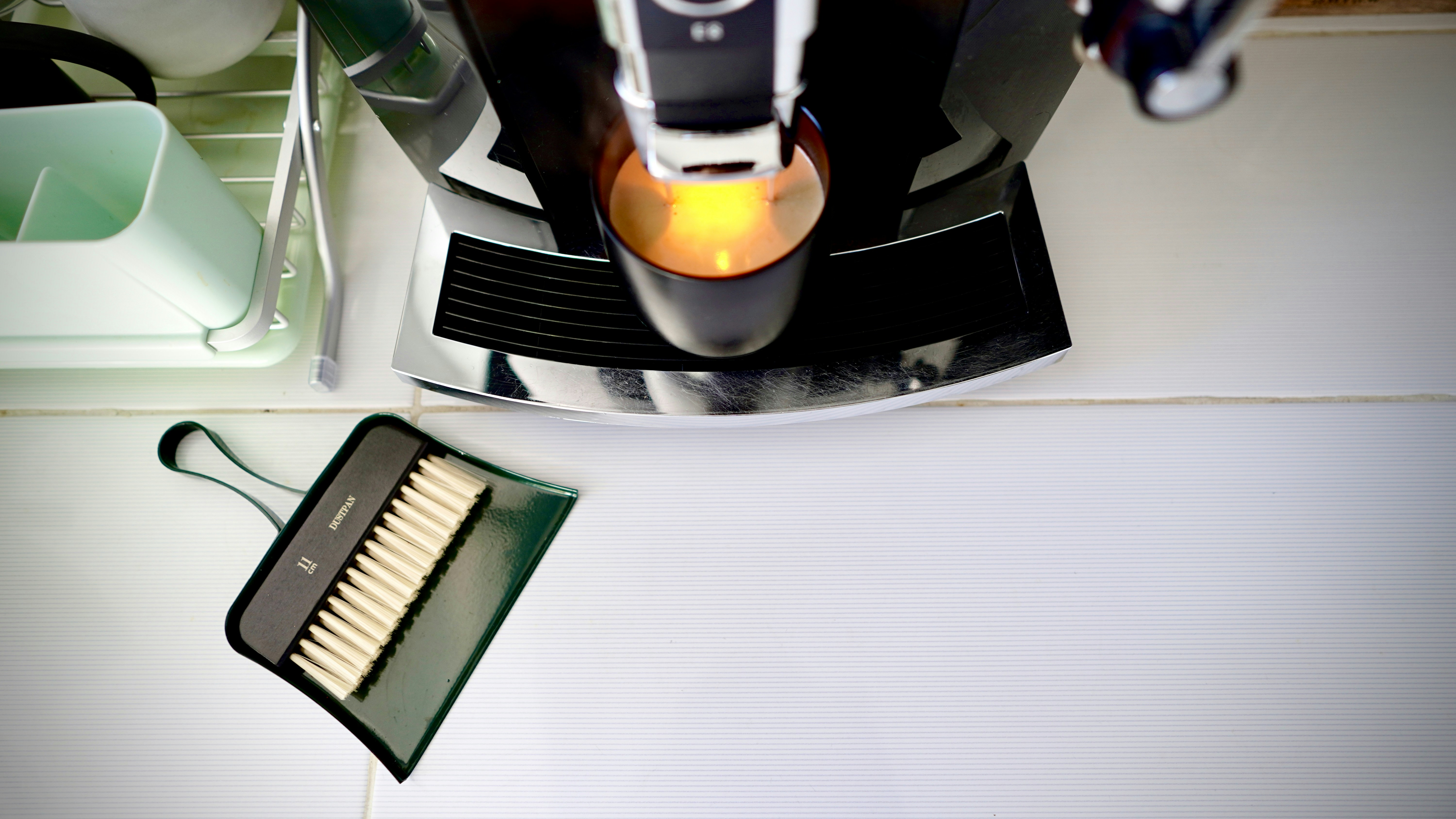 A coffee machine with a dustpan and brush.