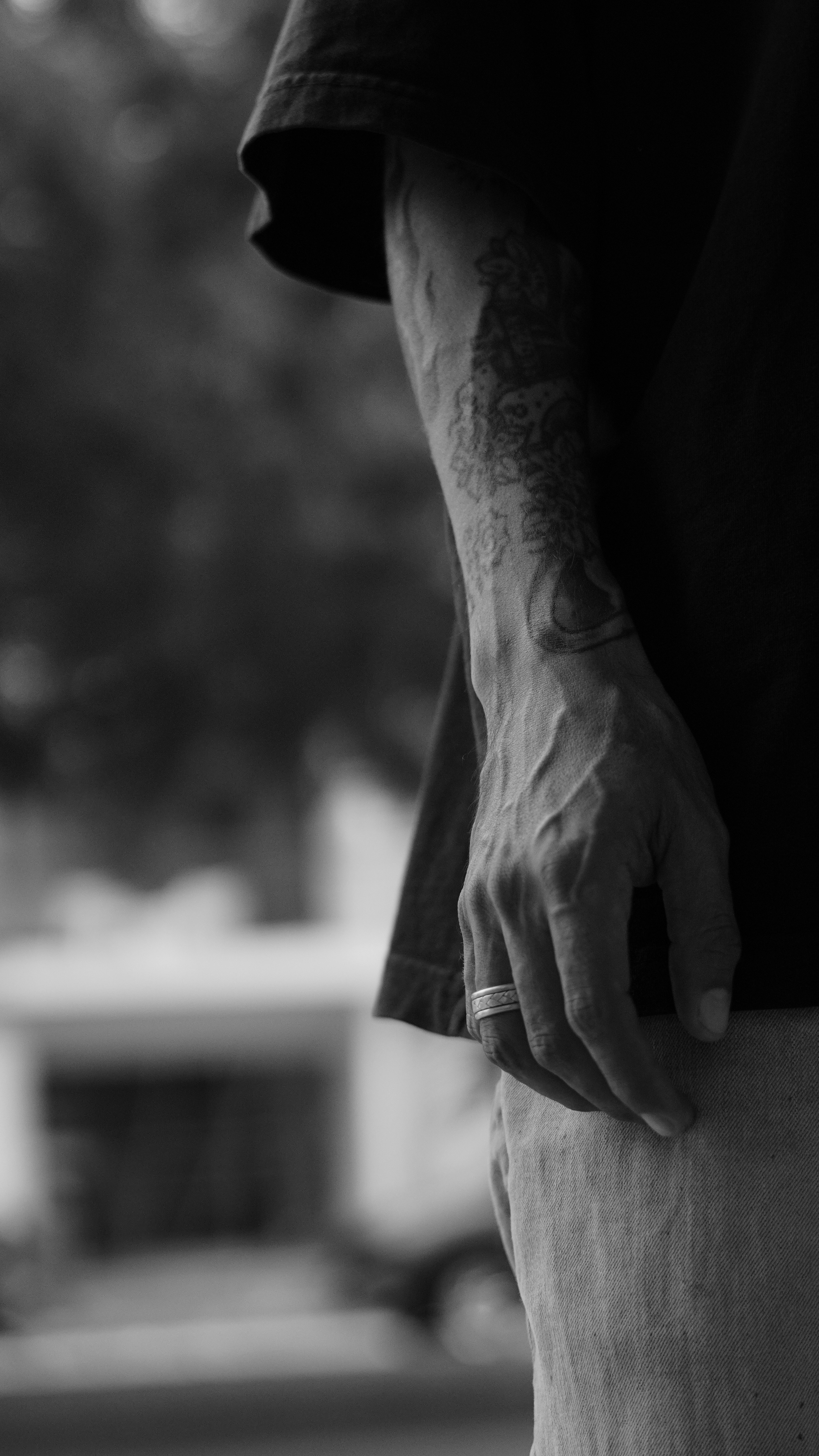 A person's arm with a tattoo and ring.