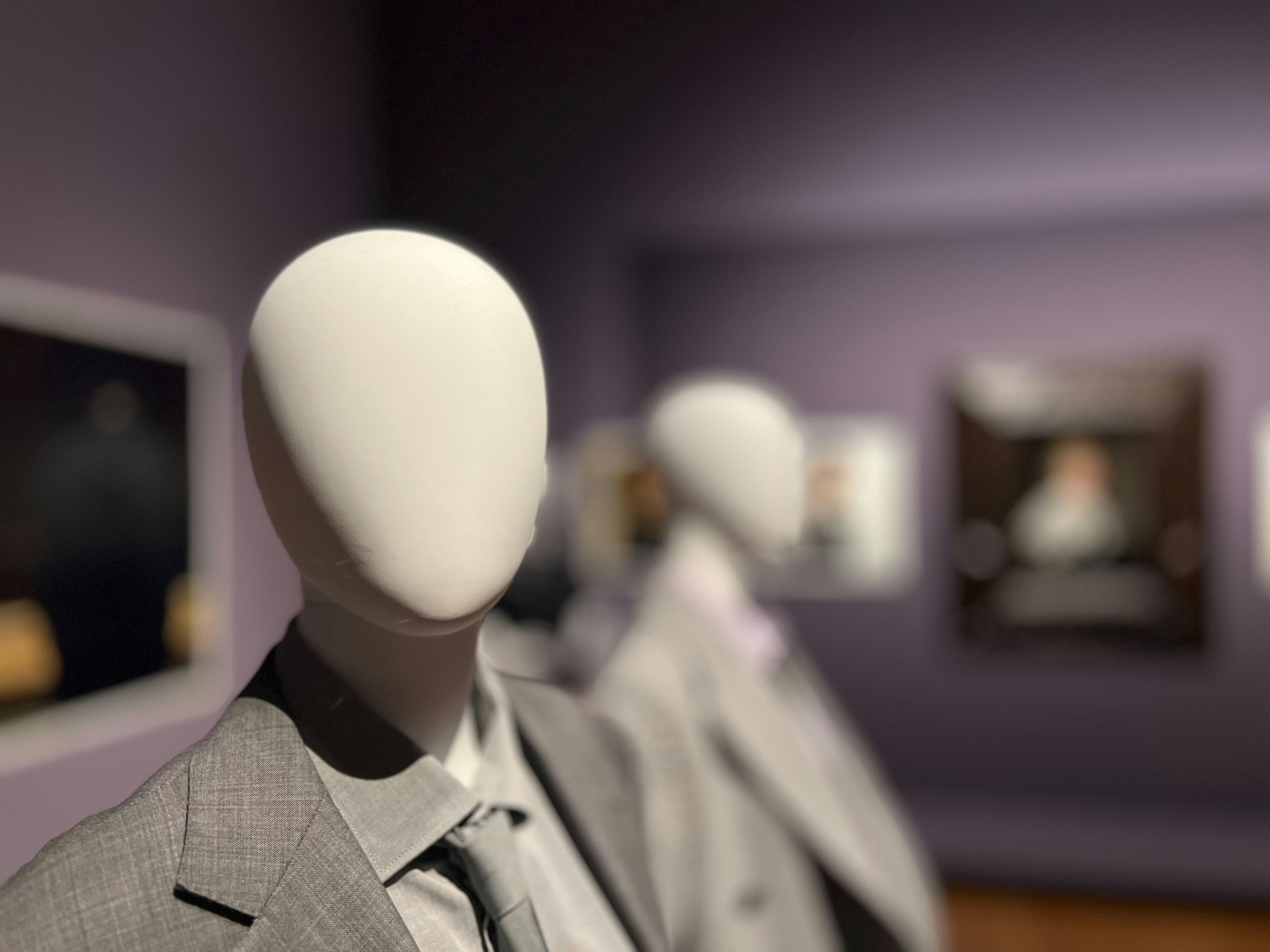 Manequins usando ternos em uma exposição de museu.