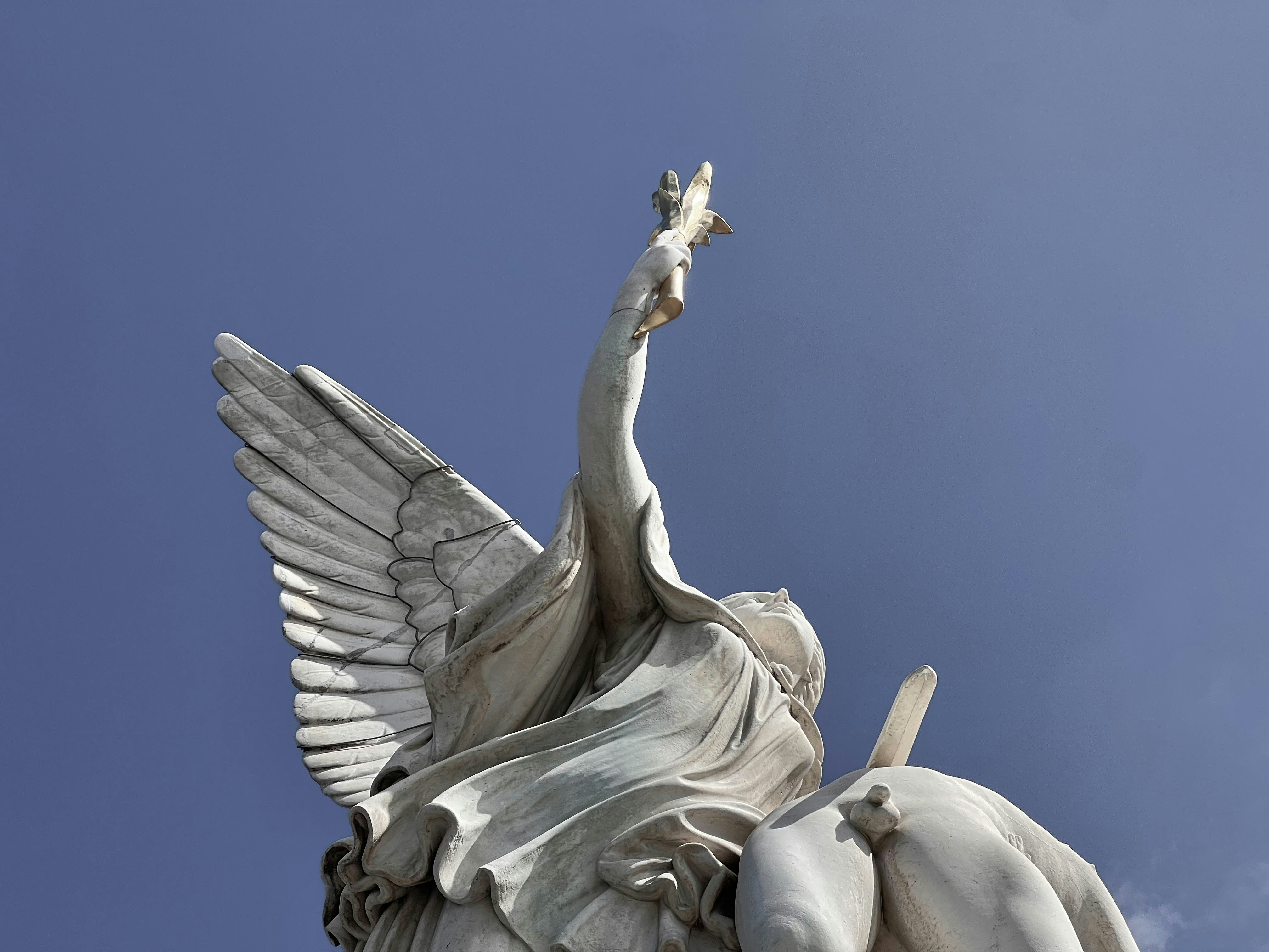 Winged statue reaching towards the sky
