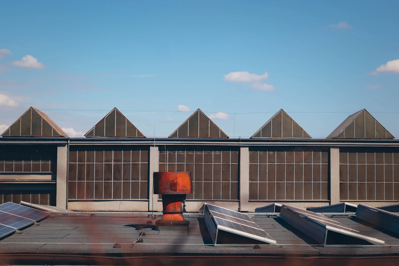 Industrial building roof fitted with rows of commercial solar panels