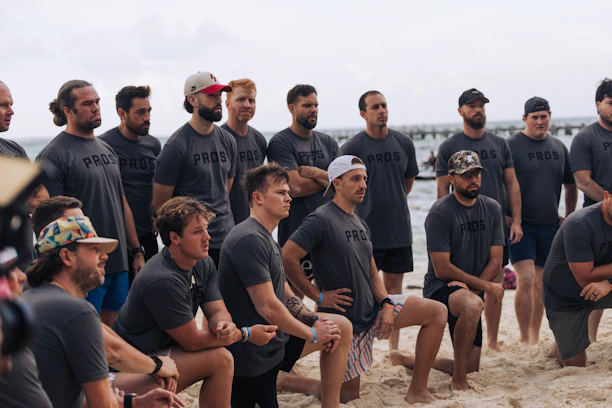 A group of men in matching shirts on a beach