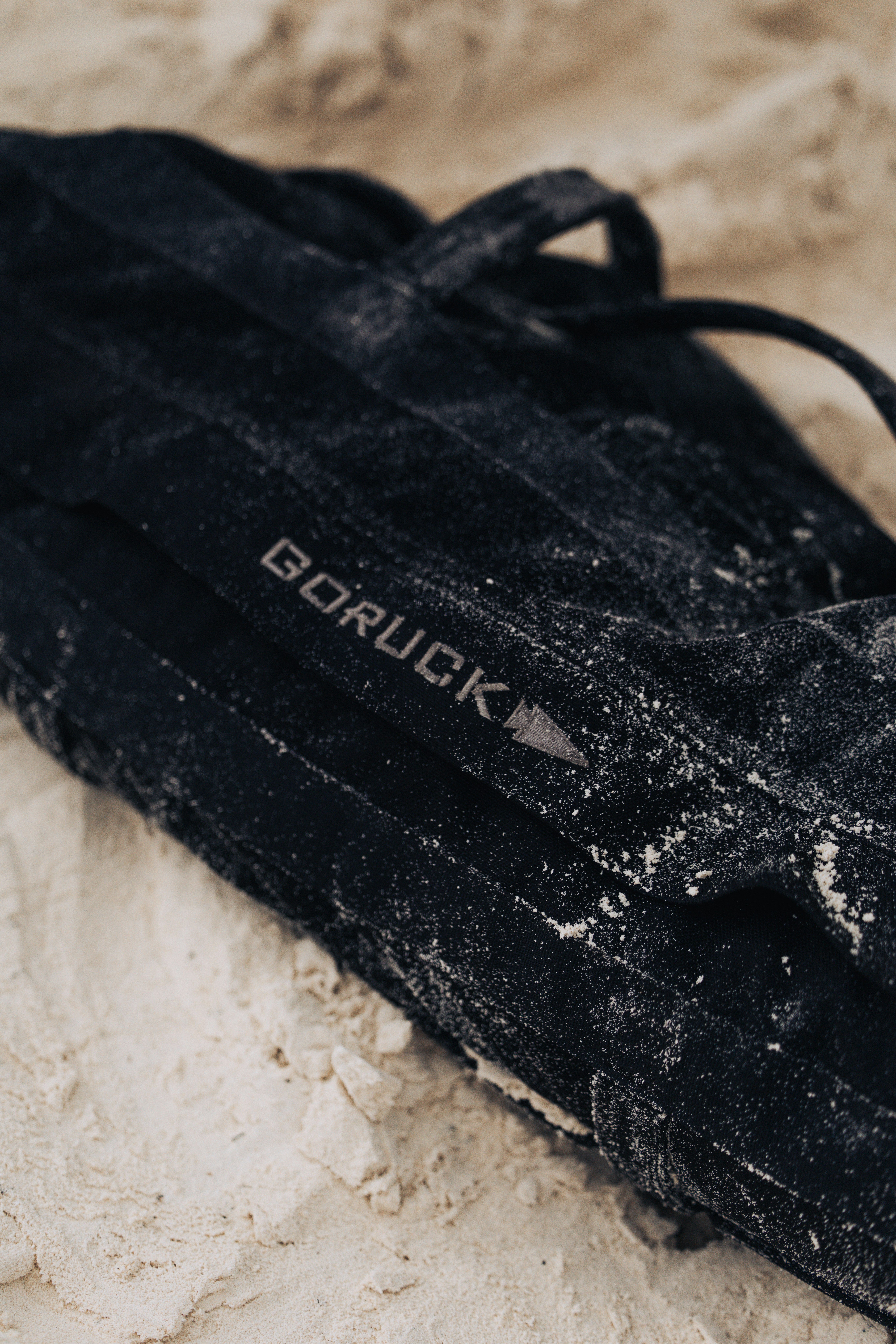 Black goruck backpack covered in sand