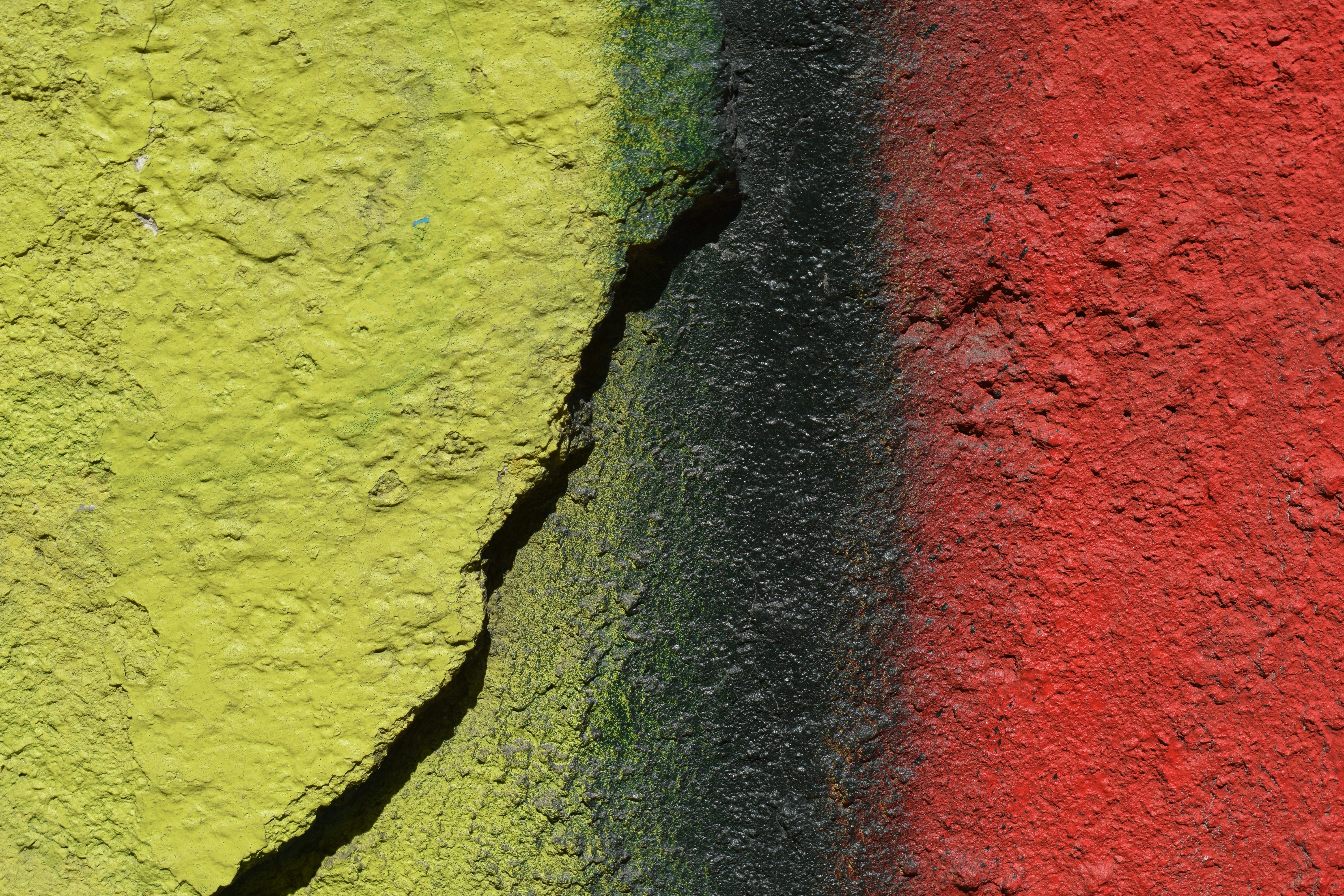 Yellow, black, and red paint with a crack
