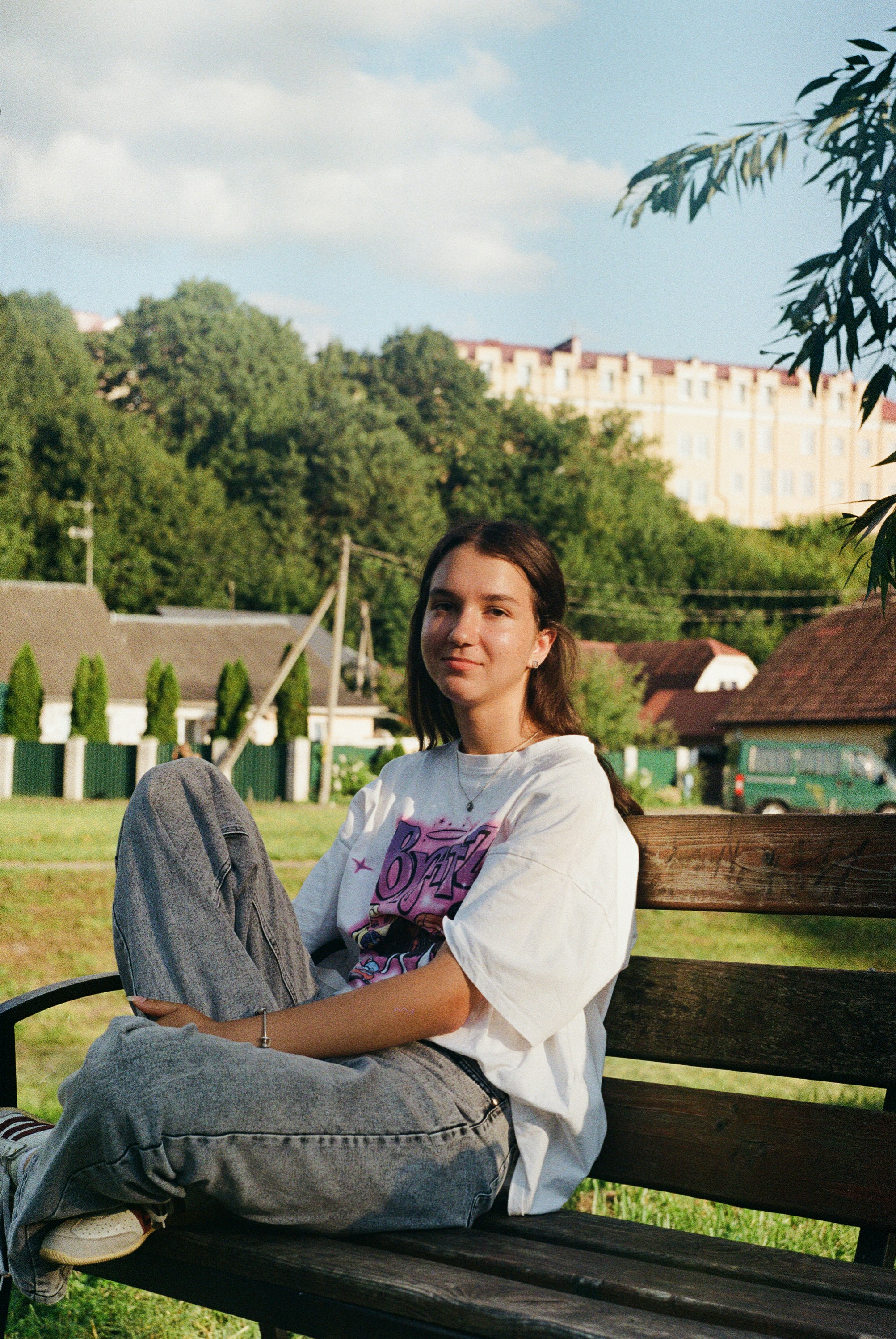 Young woman sitting on a park bench outdoors.