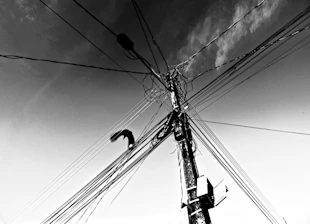 Tangled wires on a utility pole against the sky