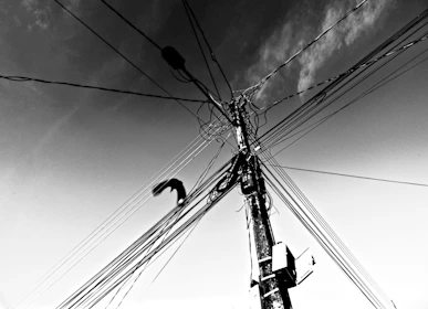 Tangled wires on a utility pole against the sky