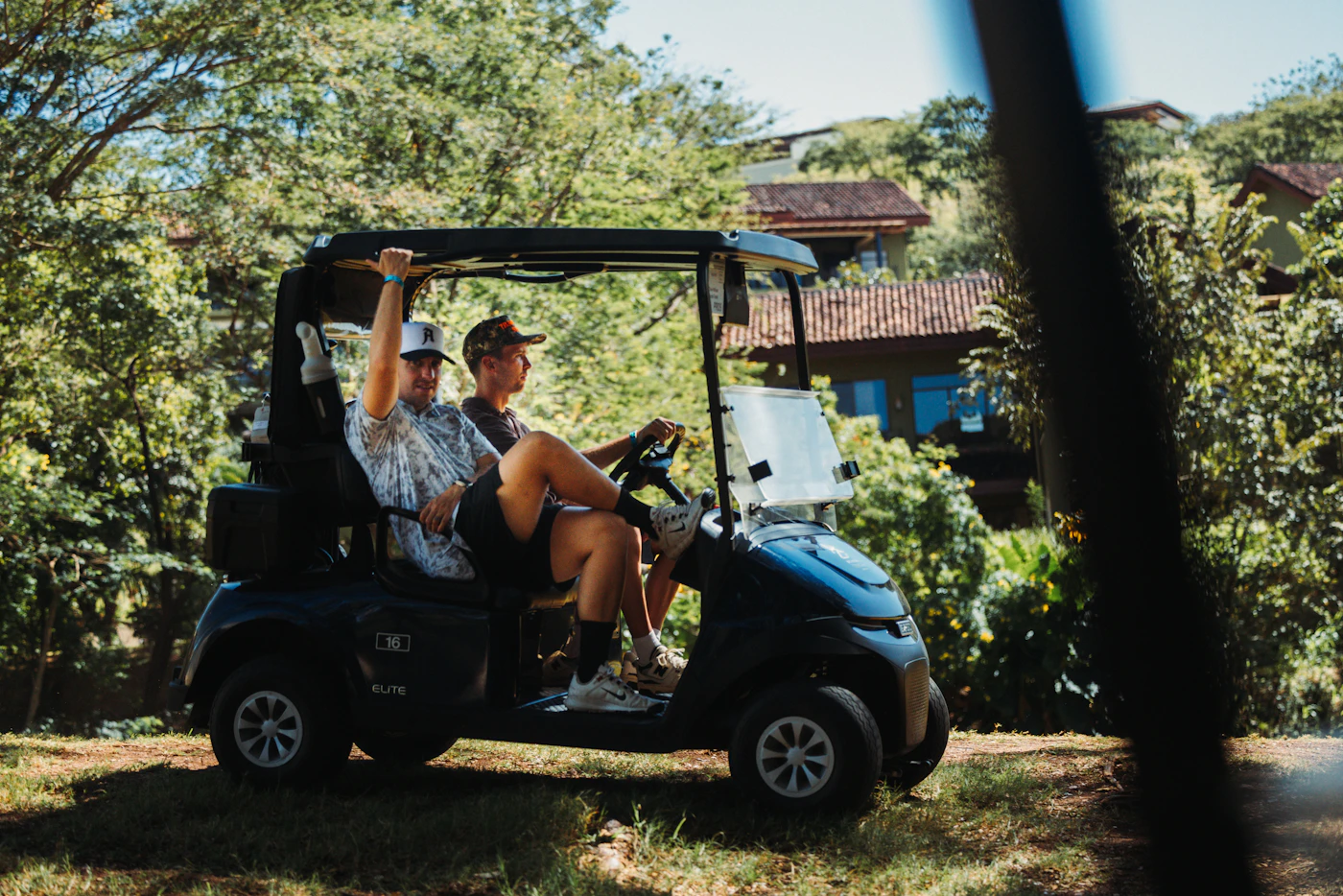 Two friends riding a golf cart, laughing