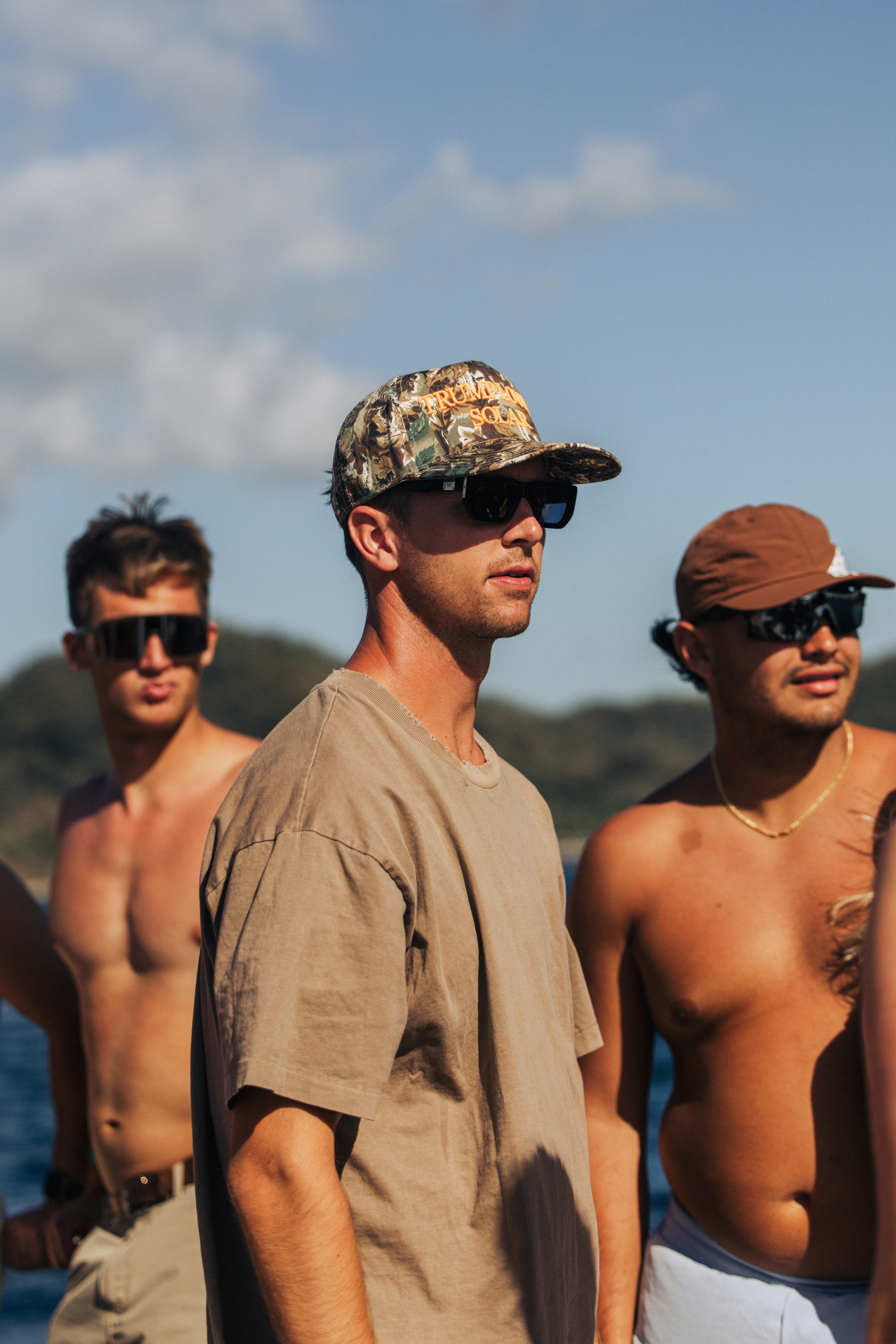 Tres jóvenes con gafas de sol y sombreros al aire libre