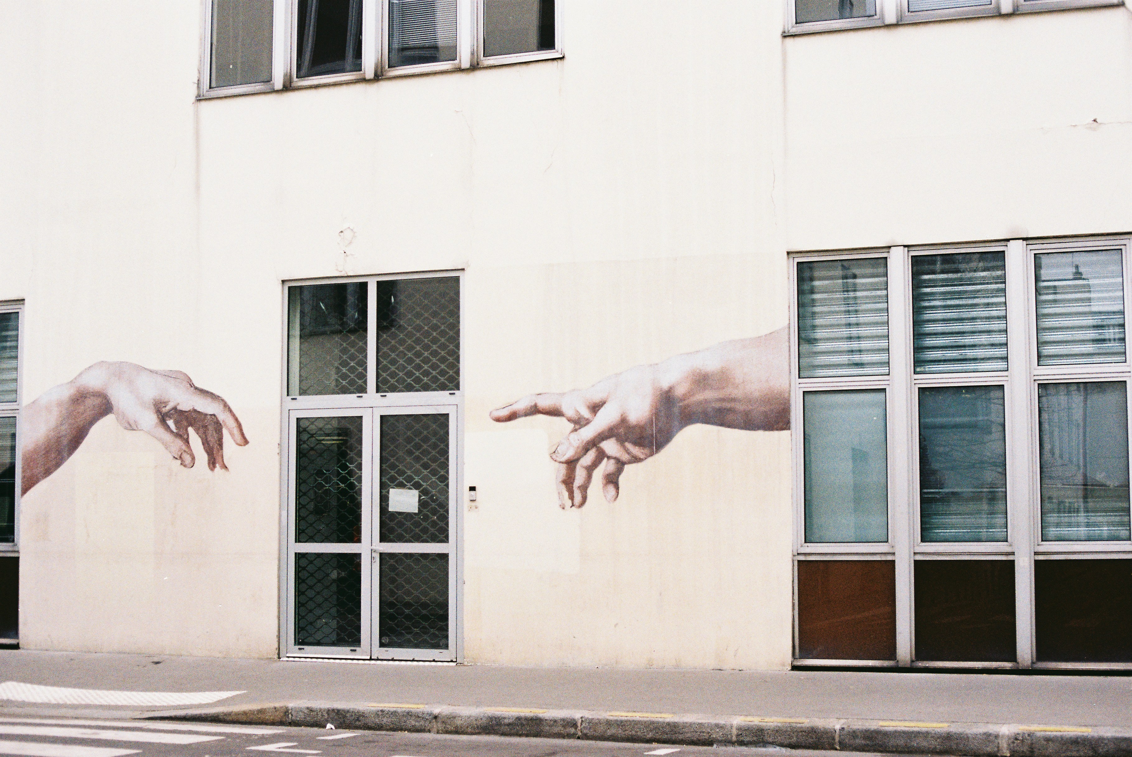 Two hands reaching out on a building