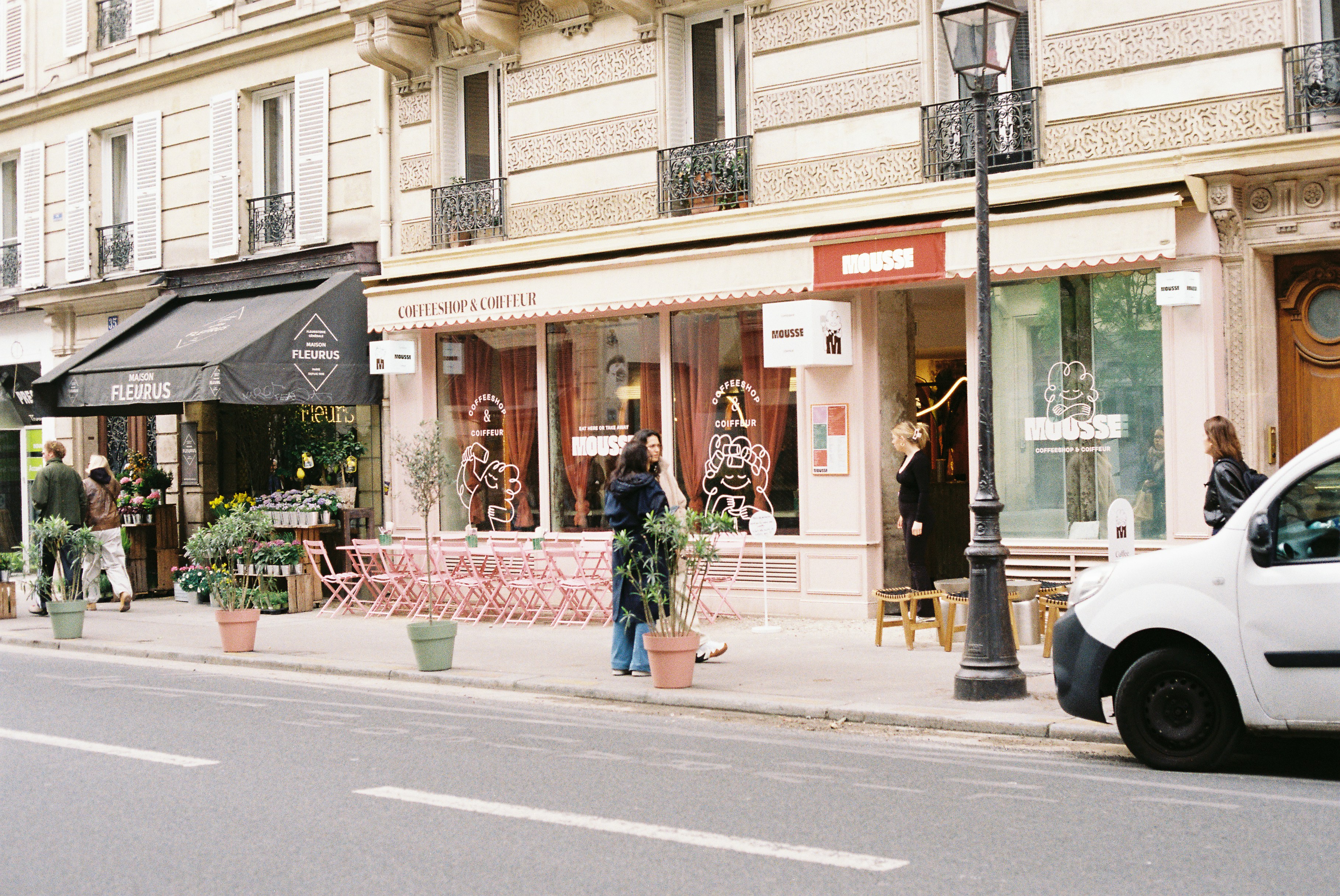 Vue de rue sur un café parisien avec terrasses extérieures