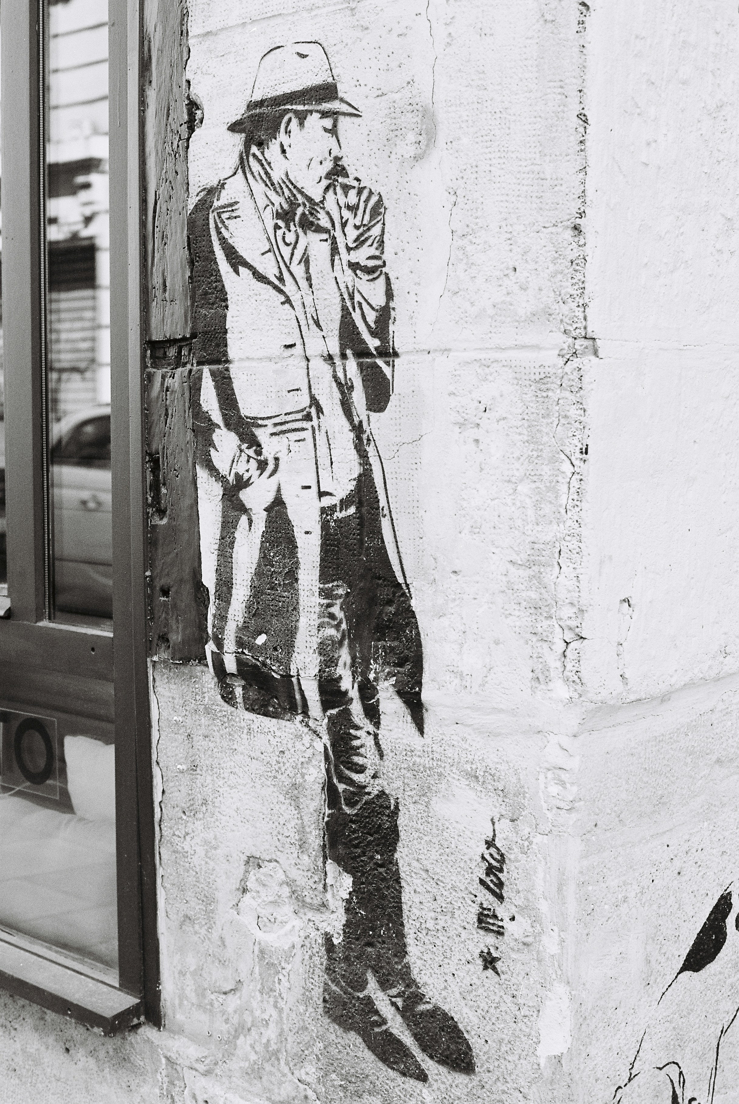 Graffiti of a man in a trench coat smoking