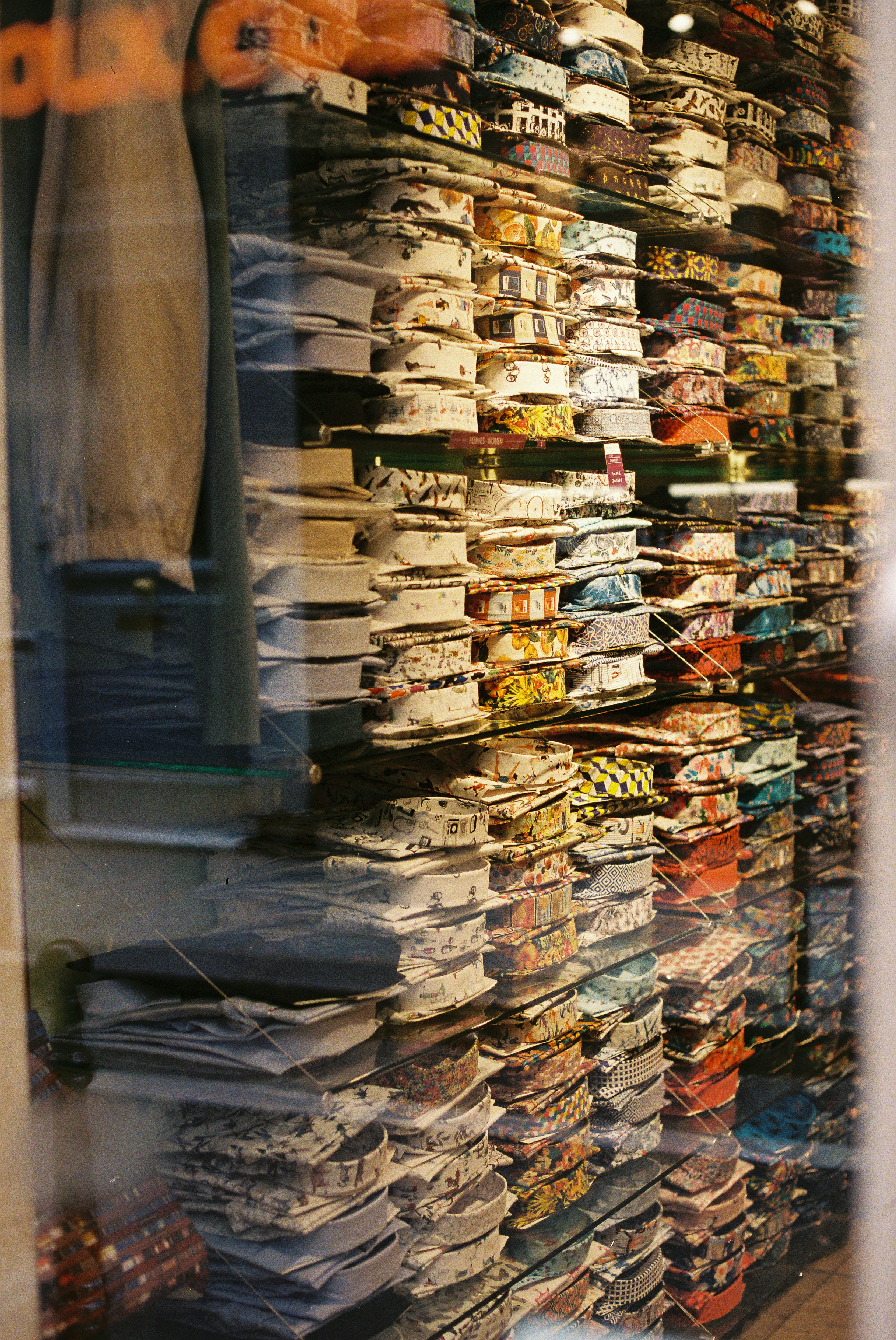 Wall of colorful folded shirts in a store window