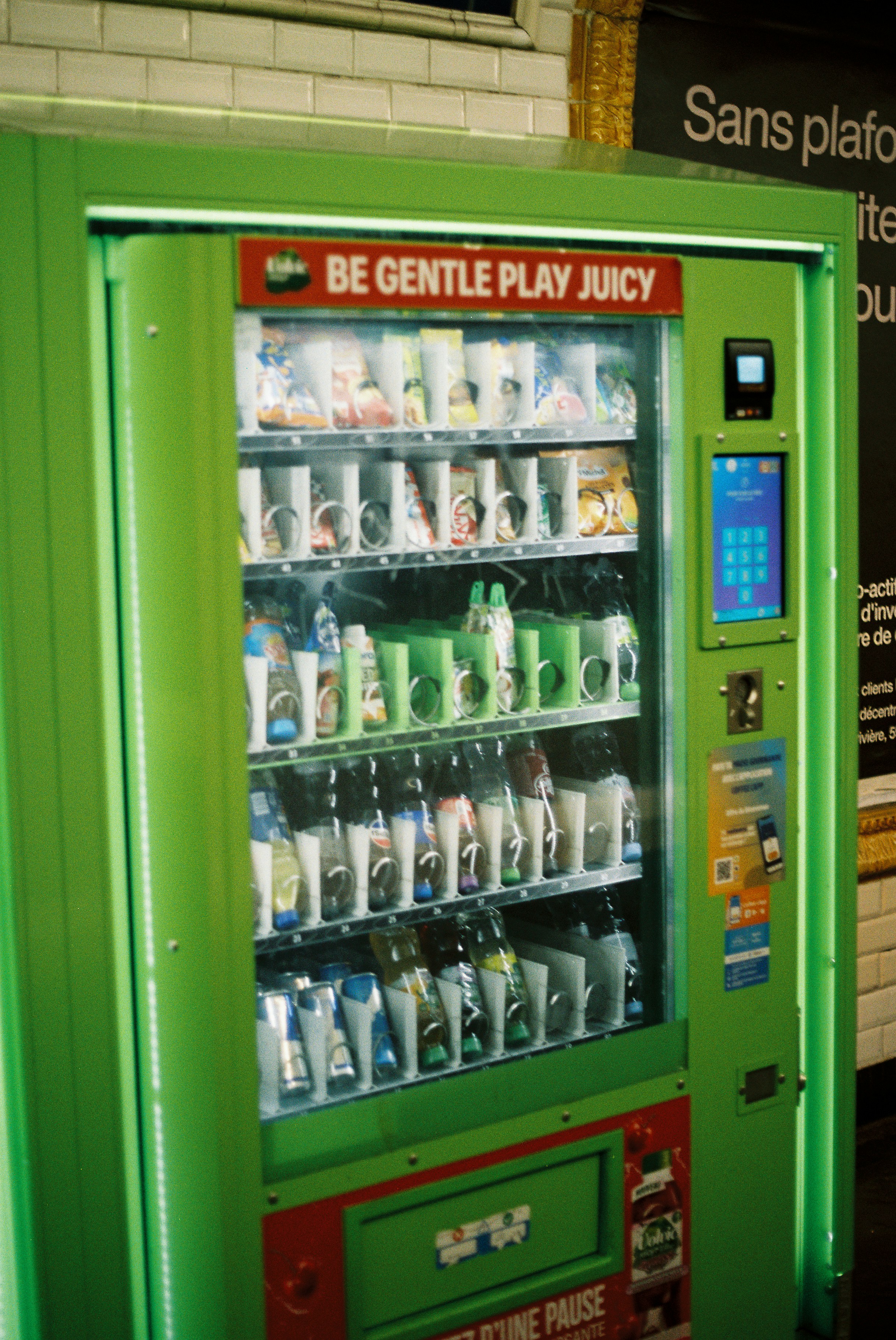 Uma máquina de venda automática verde brilhante cheia de bebidas.