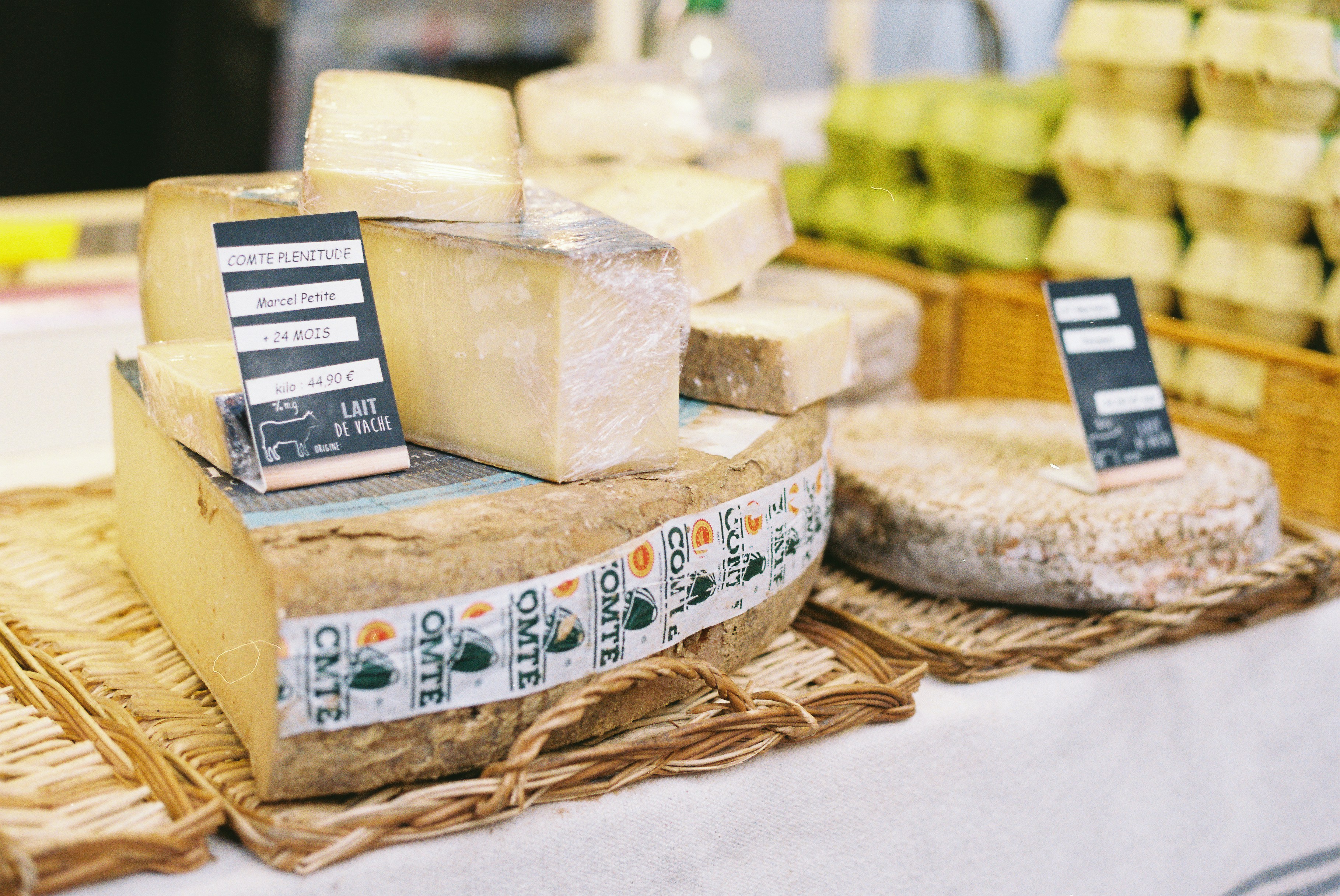 Various types of cheese displayed on a market stall.