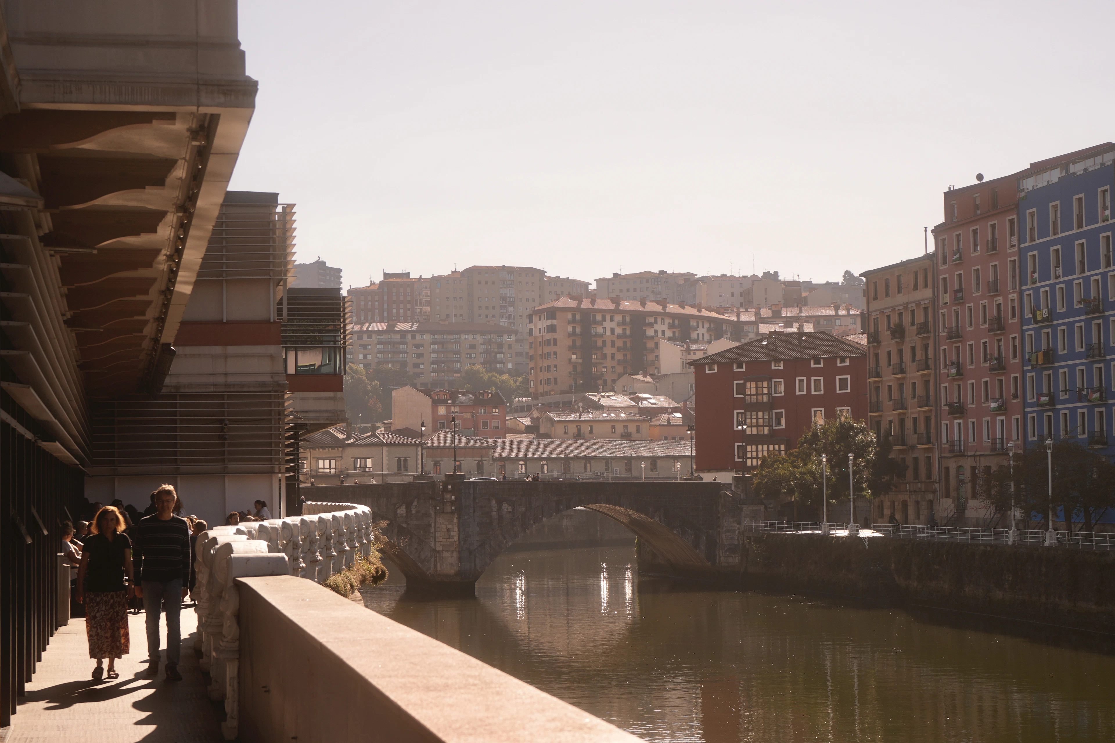 The Nervion running through Bilbao seen from under the Guggenheim canopy, bridges stepping into the haze