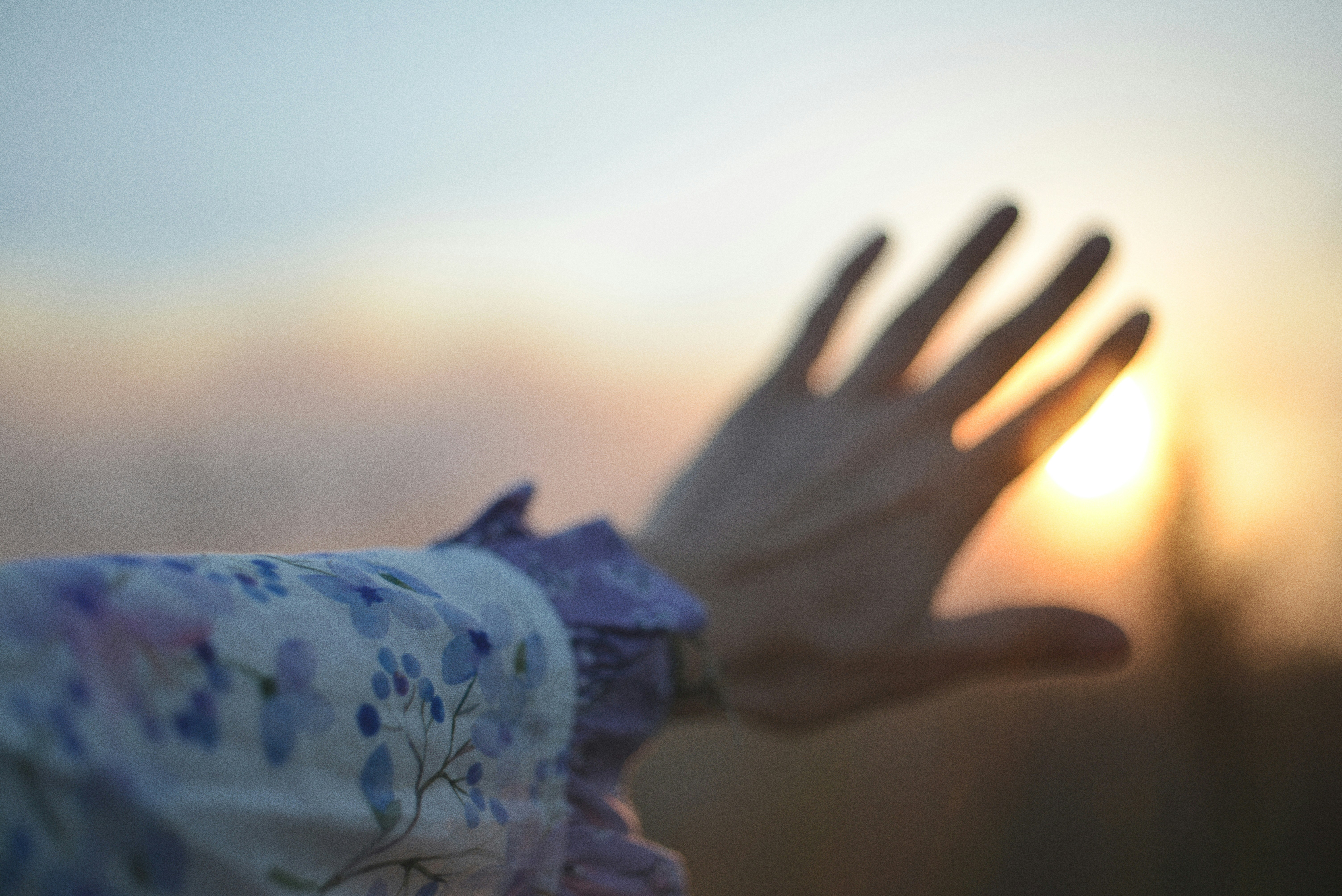 Eine Hand, die die Sonne bei Sonnenuntergang schützt