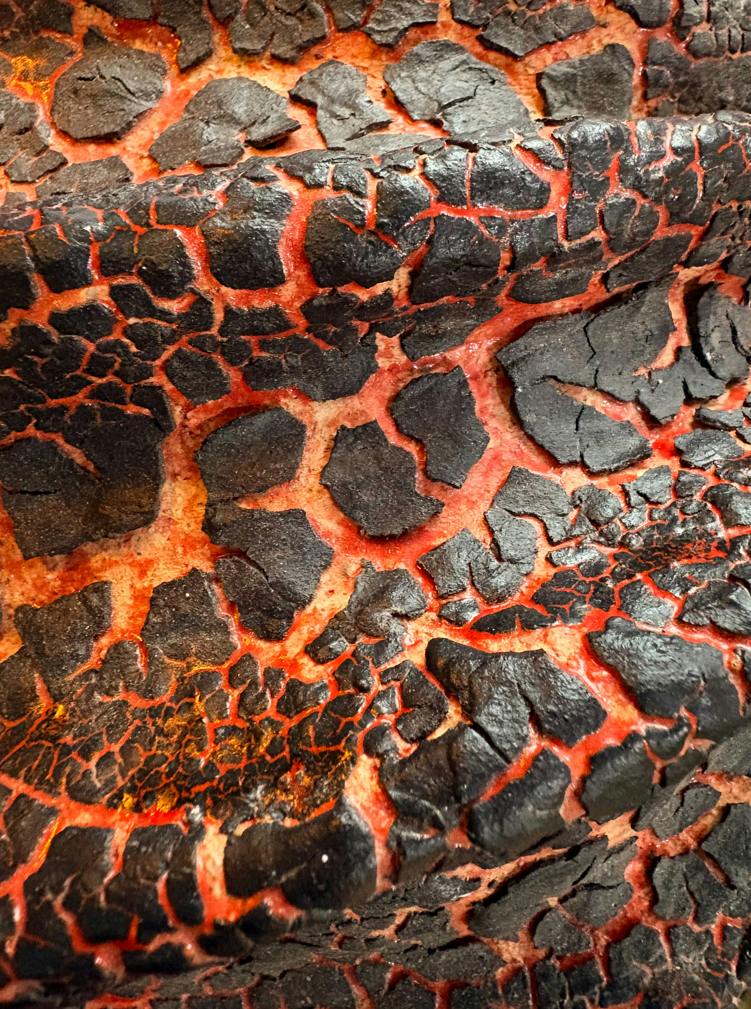 금이 간 검은 표면에 붉게 빛나는 균열이 있었다