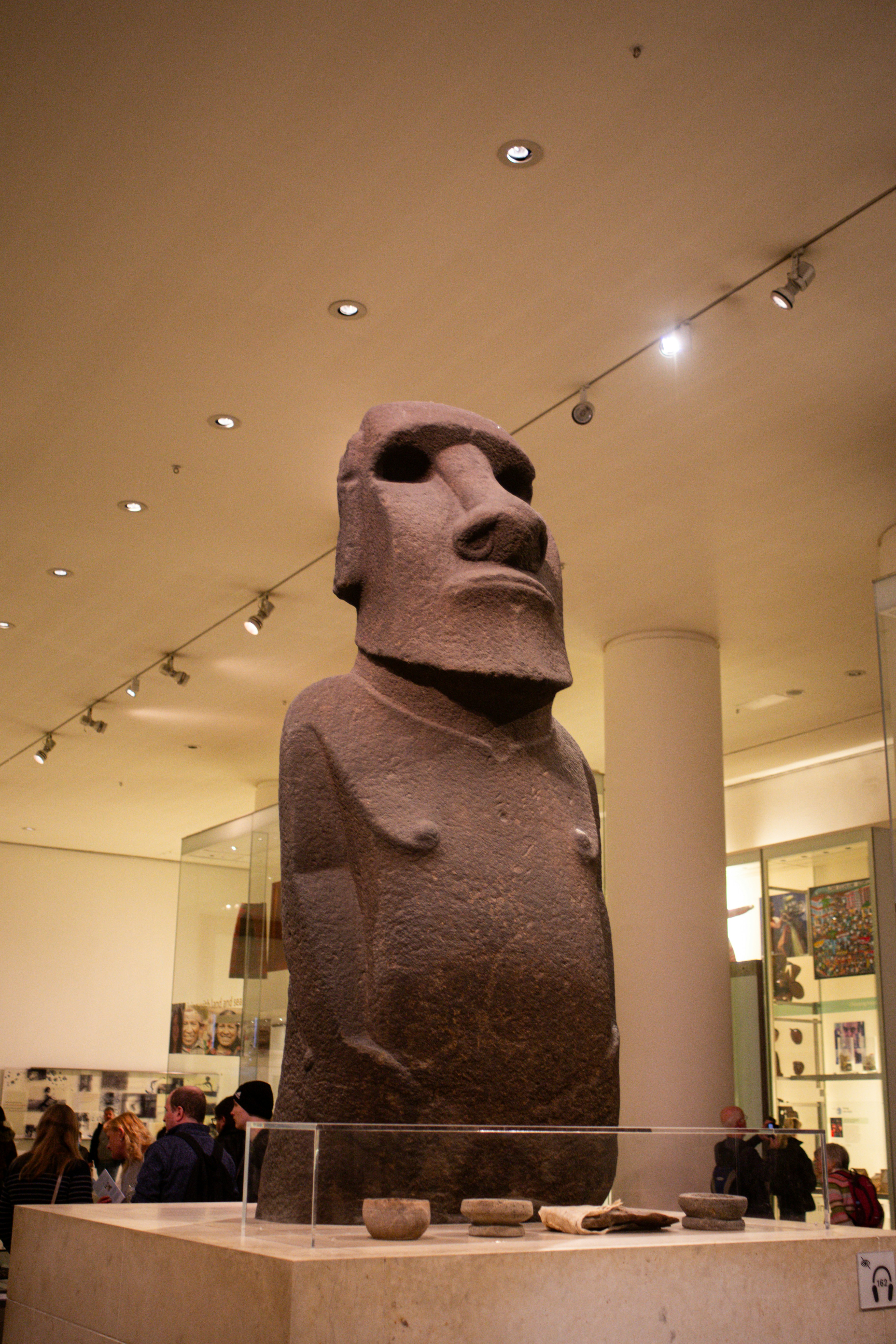 A large moai statue in a museum exhibit.