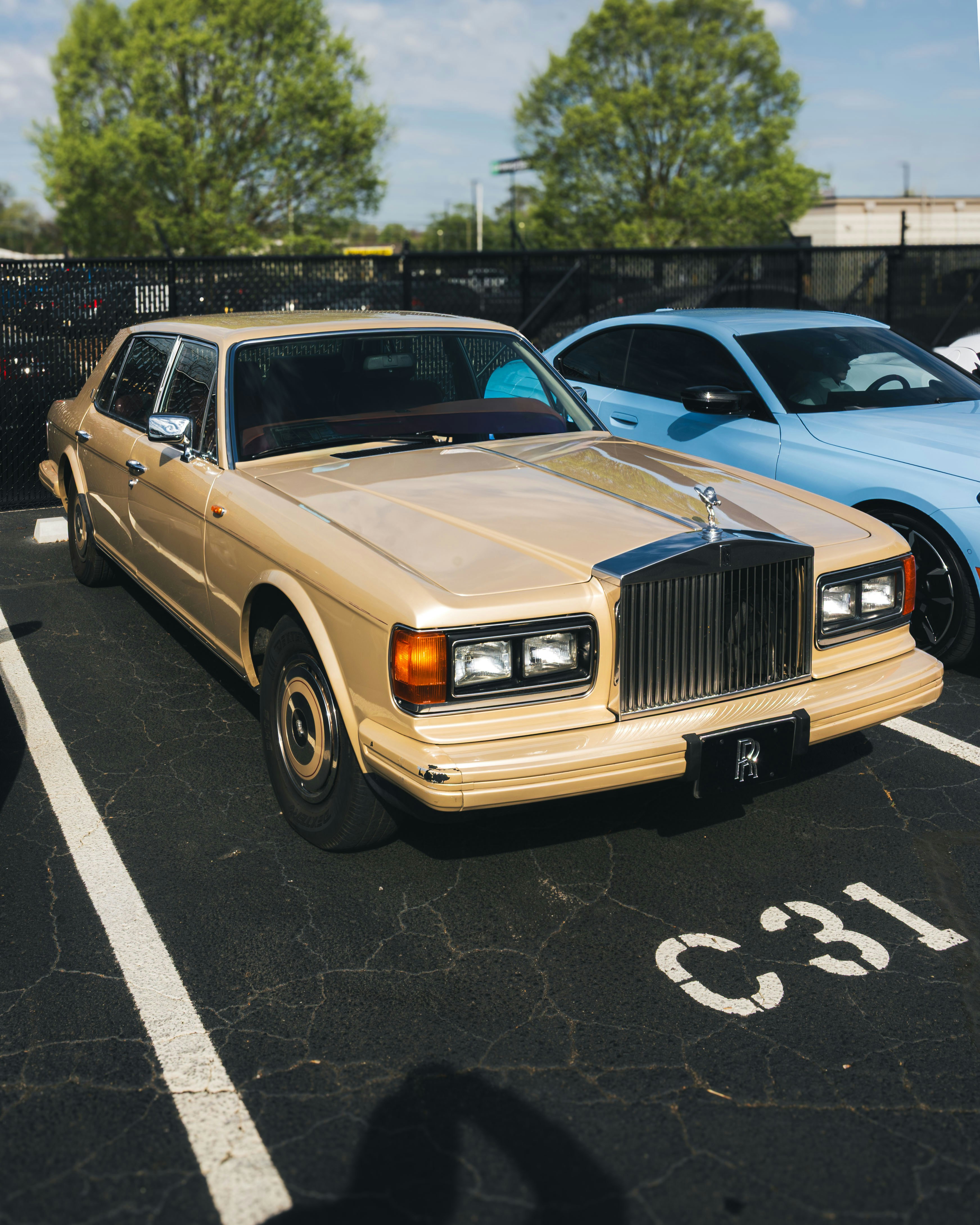 Eine vintage goldene Limousine steht auf einem Parkplatz.