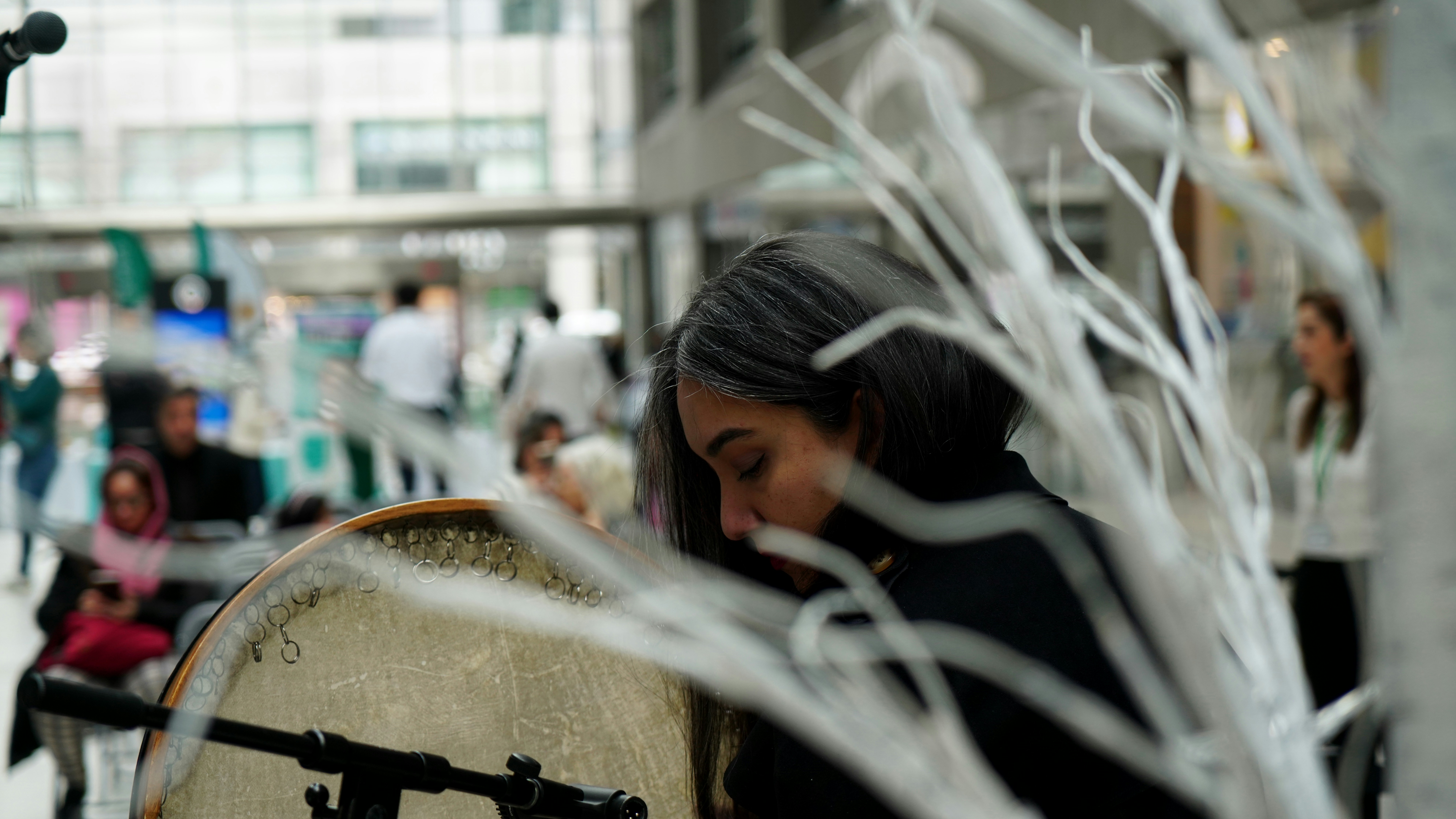 Woman playing a drum in a public space