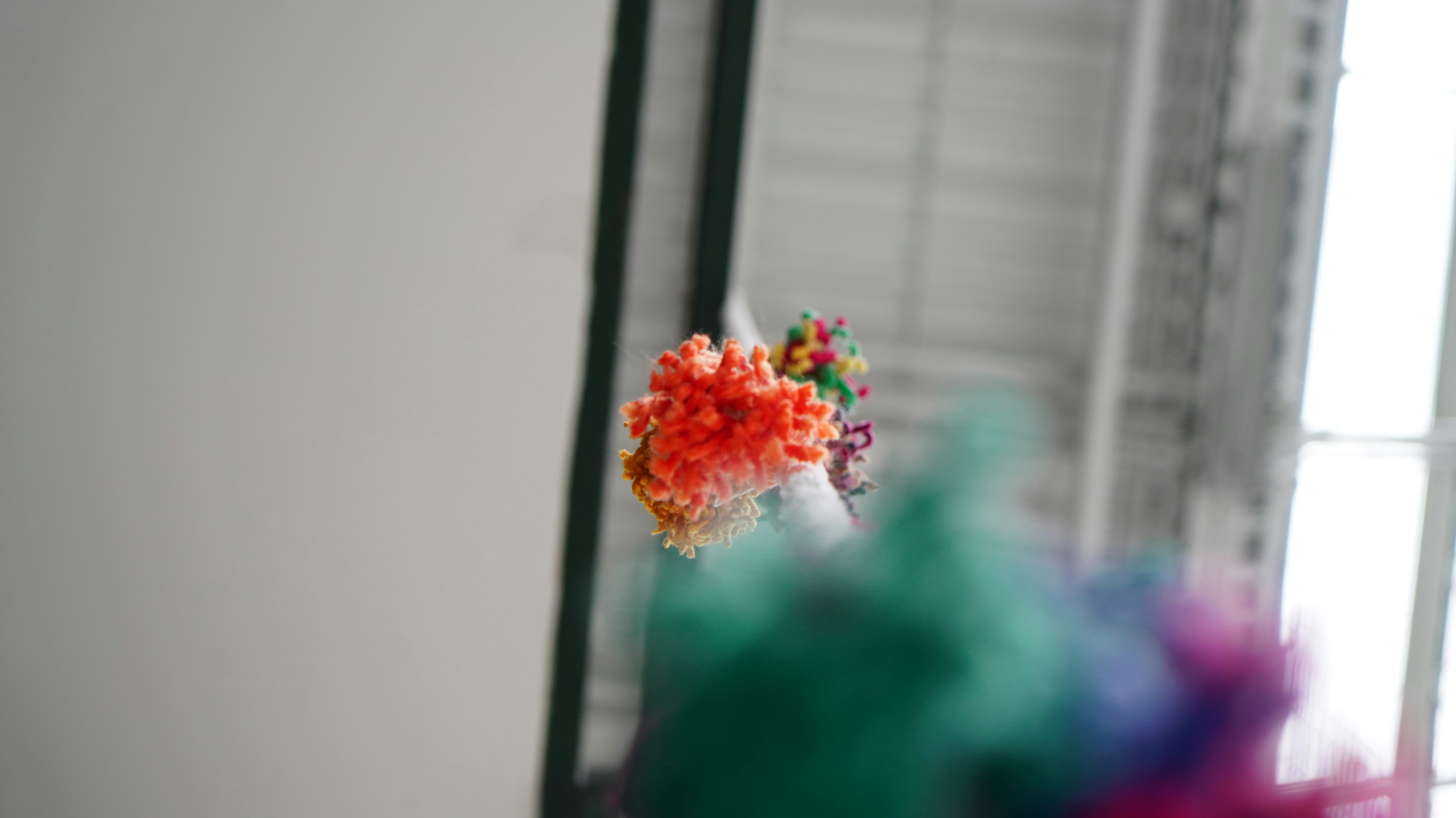 Colorful pom-poms hanging from a string