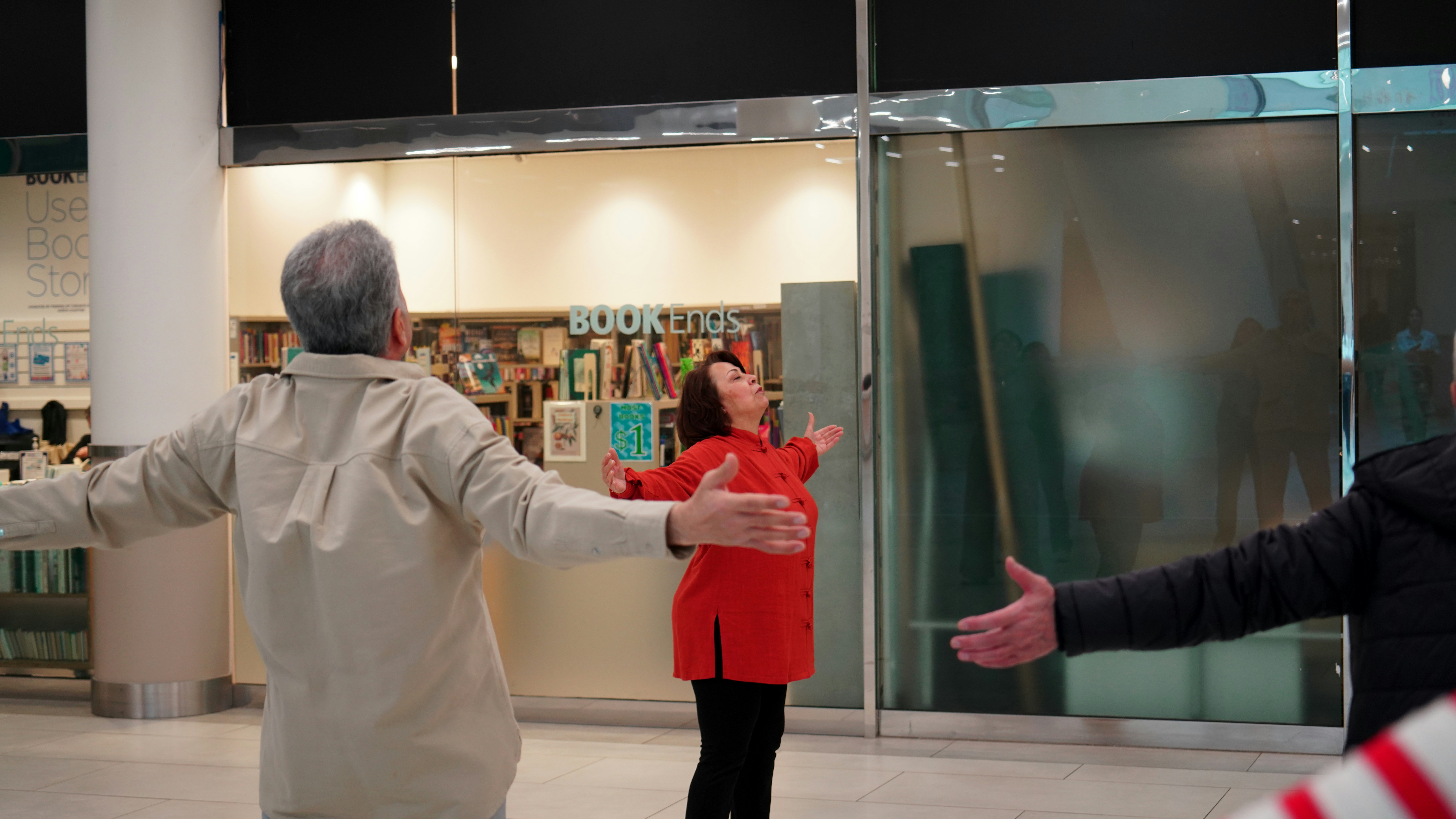 Three people with arms outstretched in a welcoming gesture.