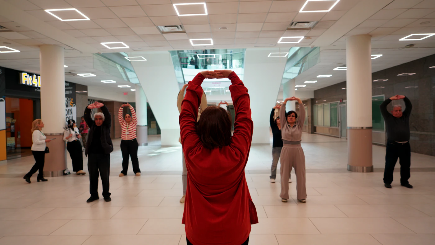 People practicing gentle tai chi movement indoors