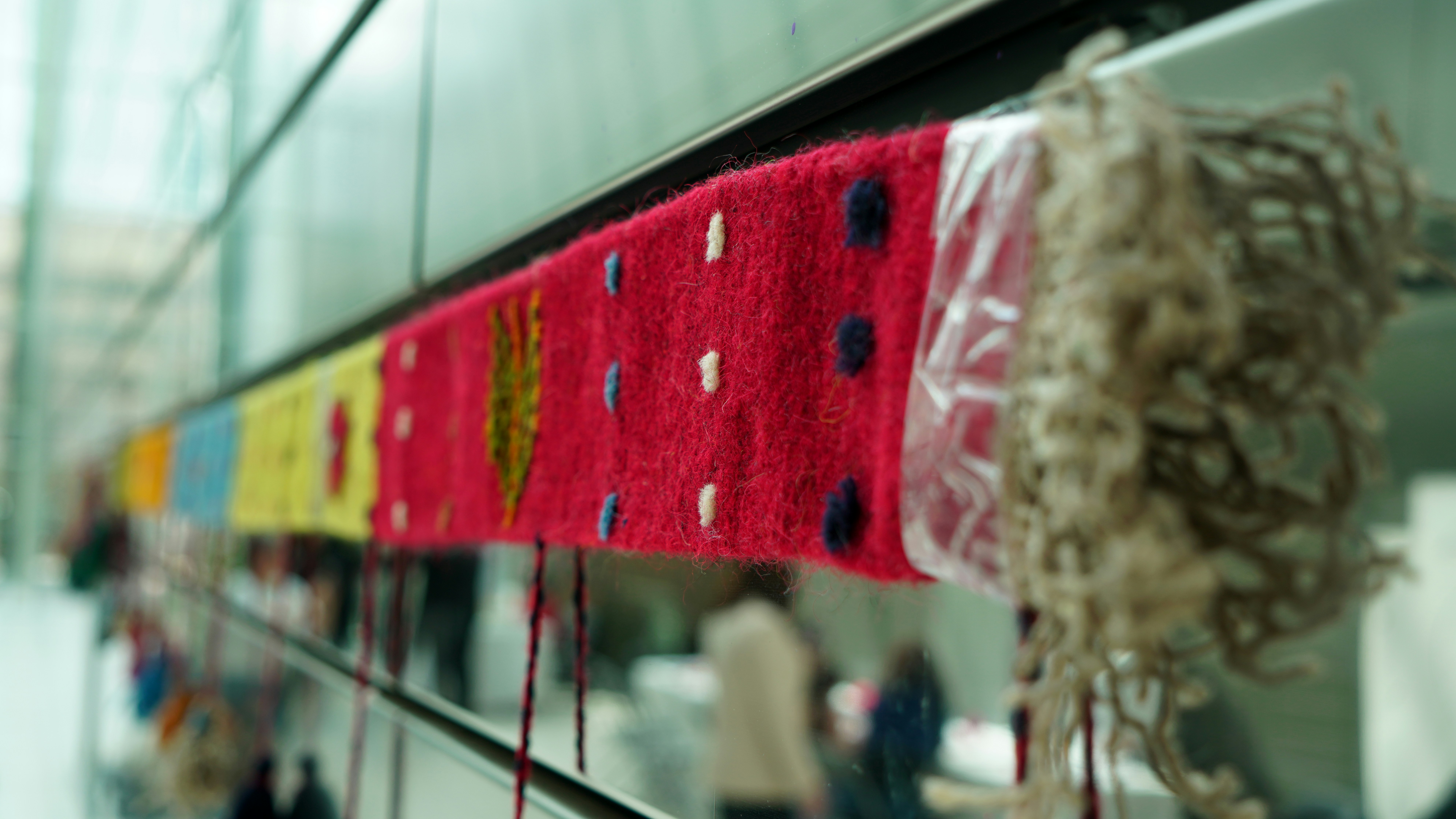 Colorful knitted fabric art with polka dots and fringe