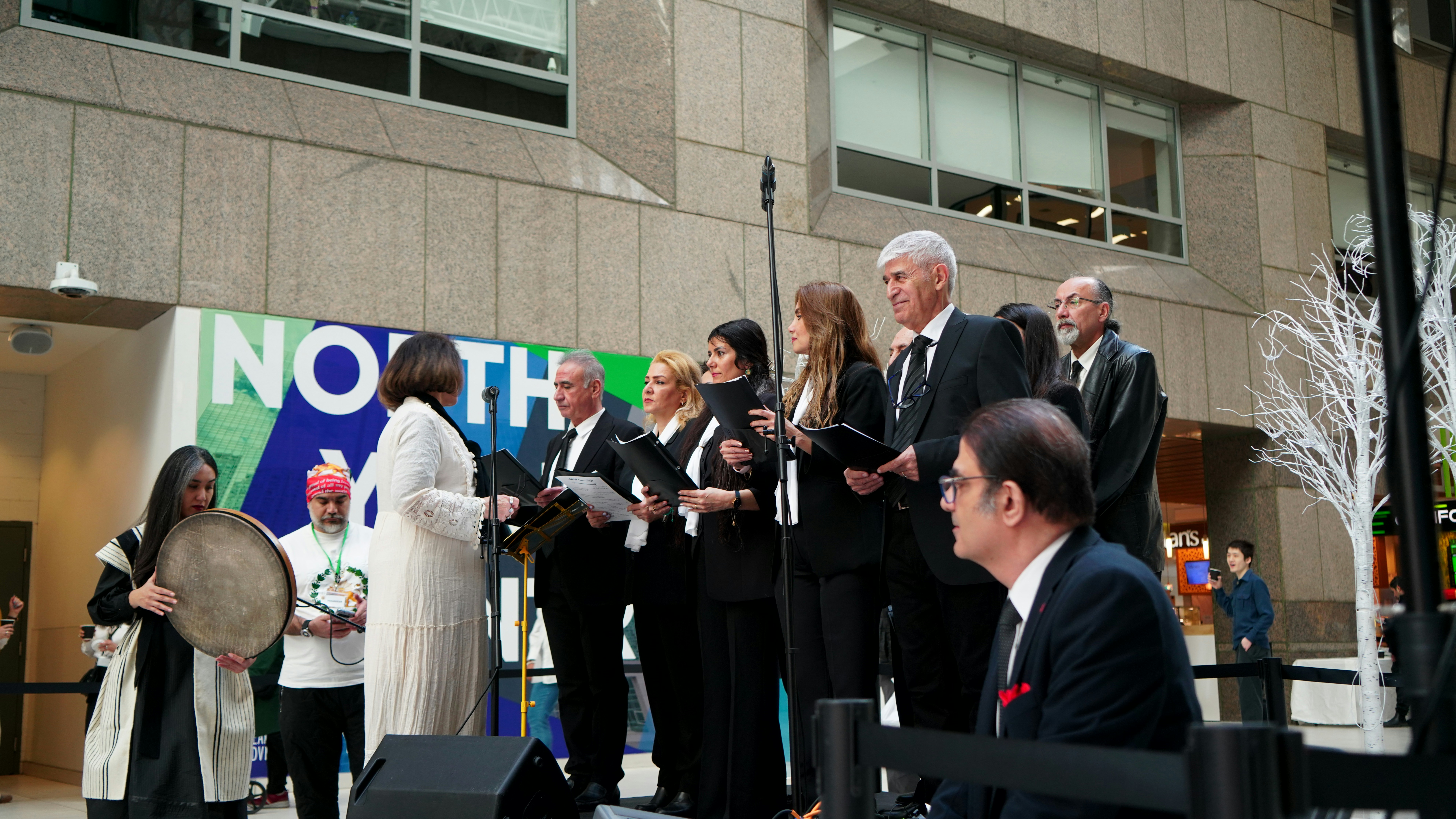 A choir performs outdoors in front of a building.