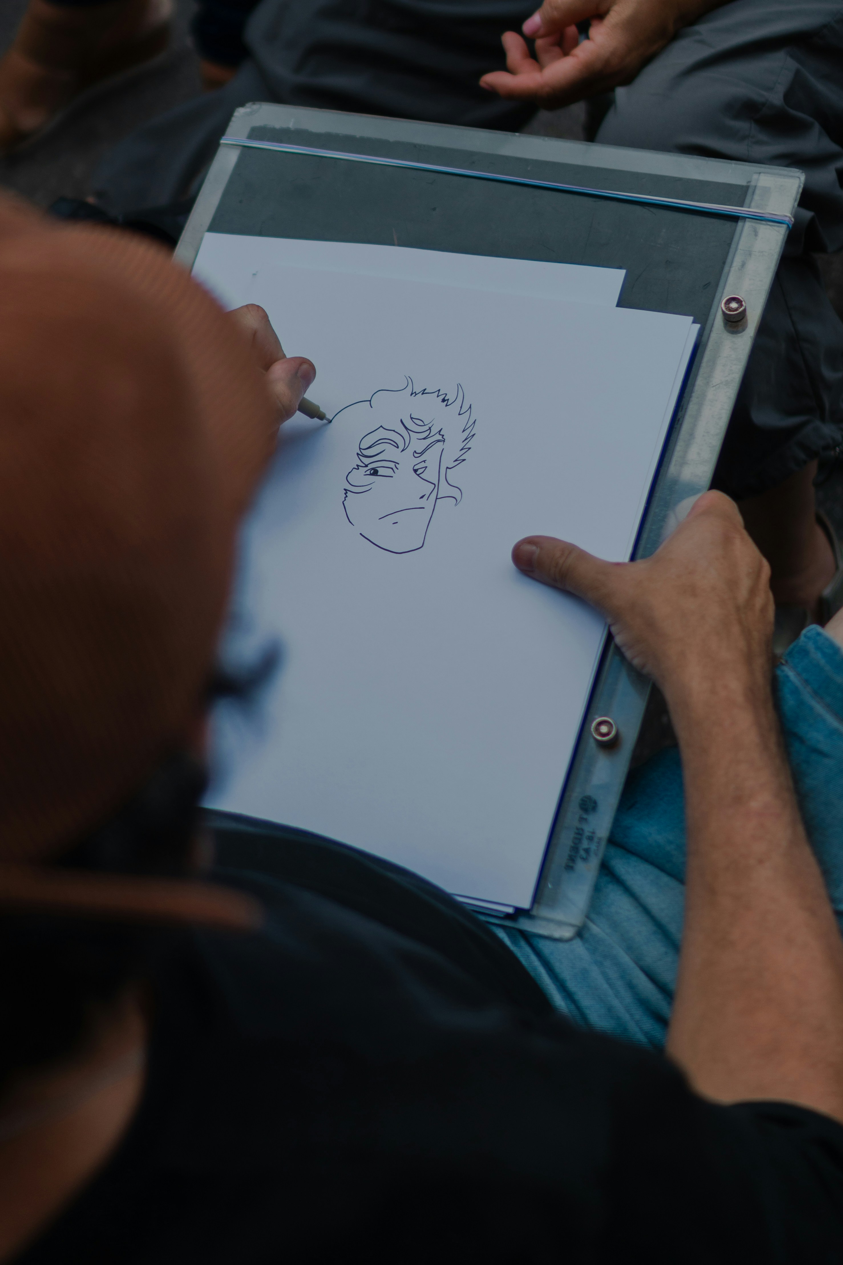 Artista che disegna un volto a vignetto su carta