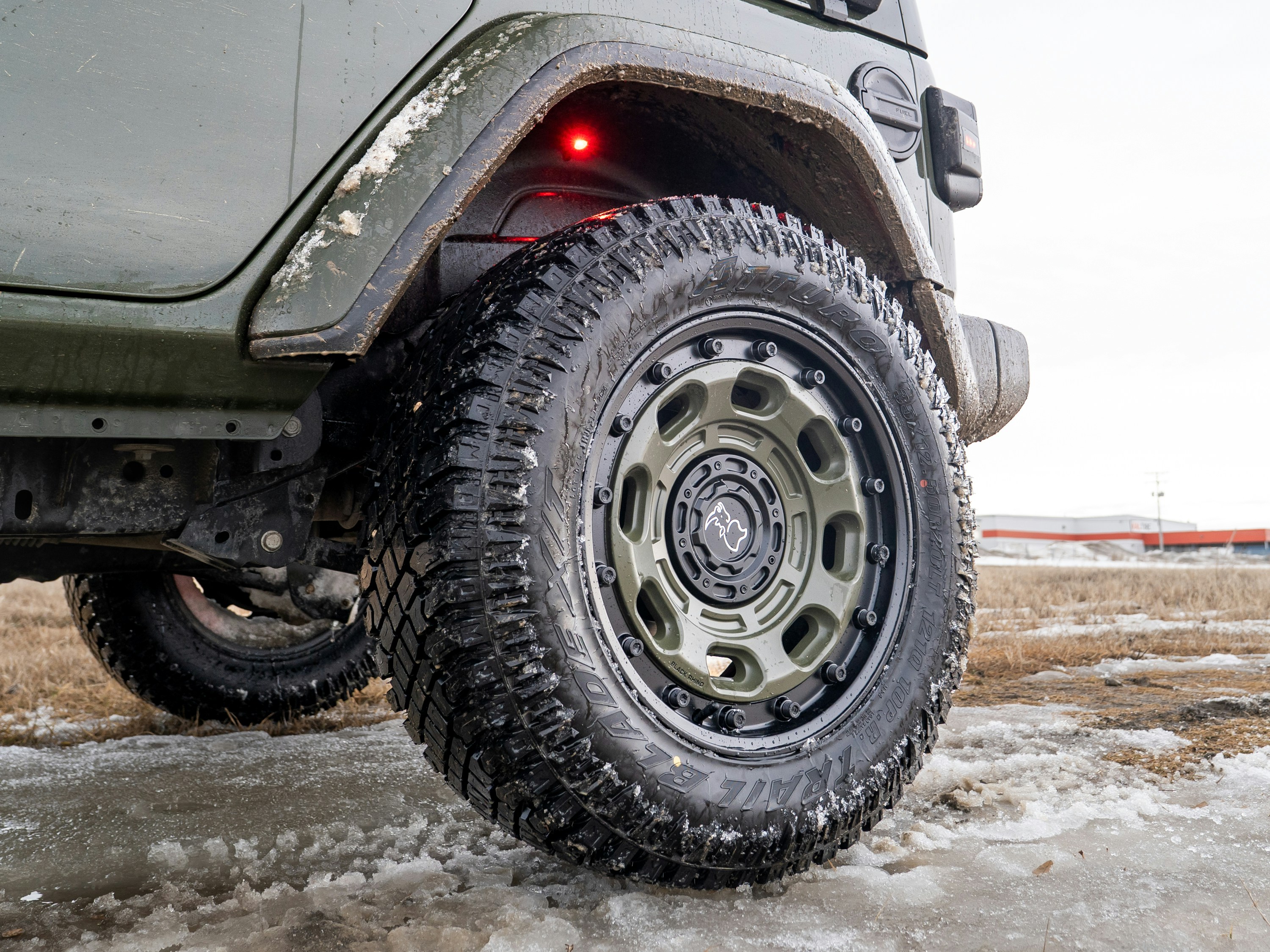 Close-up of a rugged off-road tire on a green vehicle