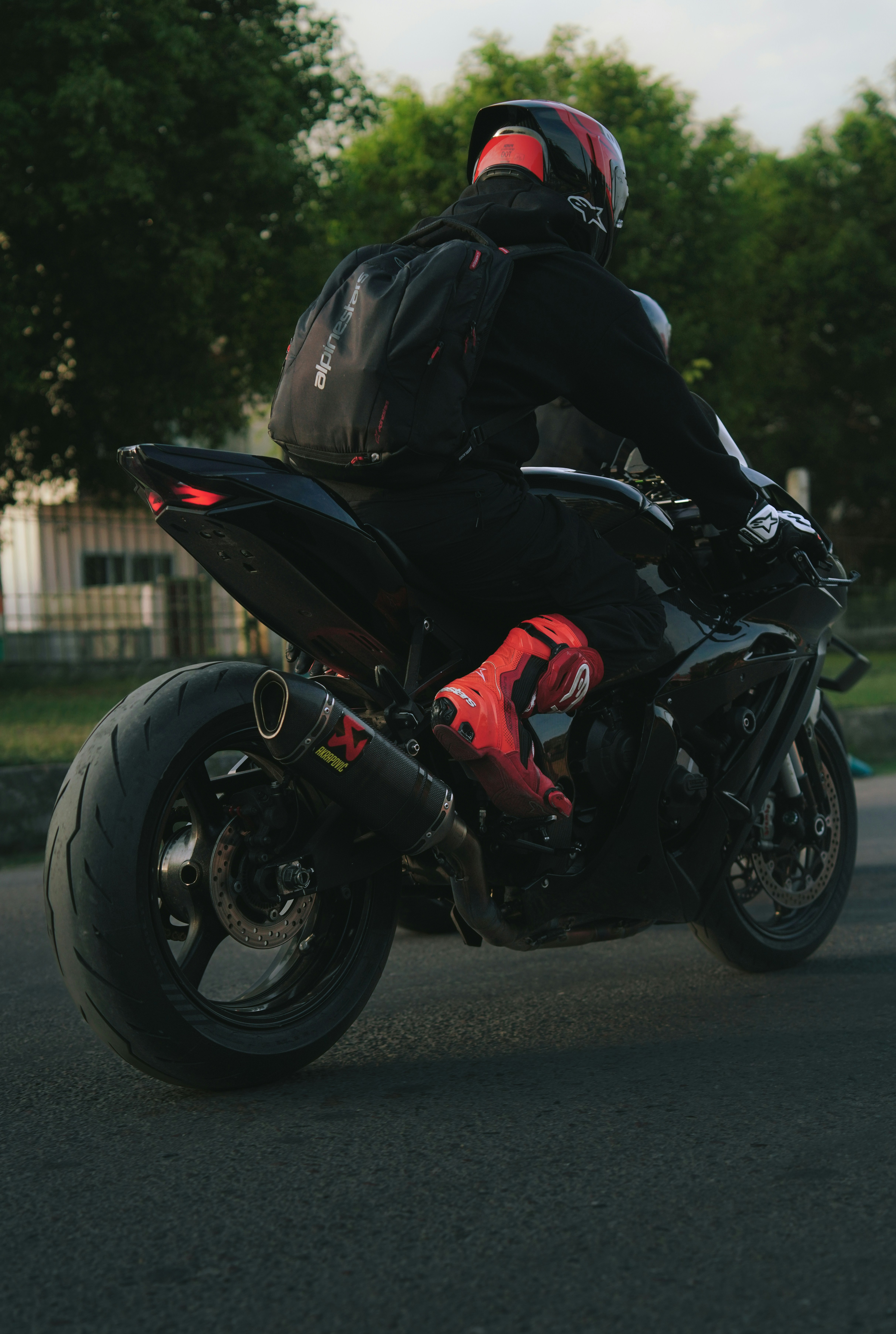 Uma pessoa pilotando uma motocicleta preta numa estrada.