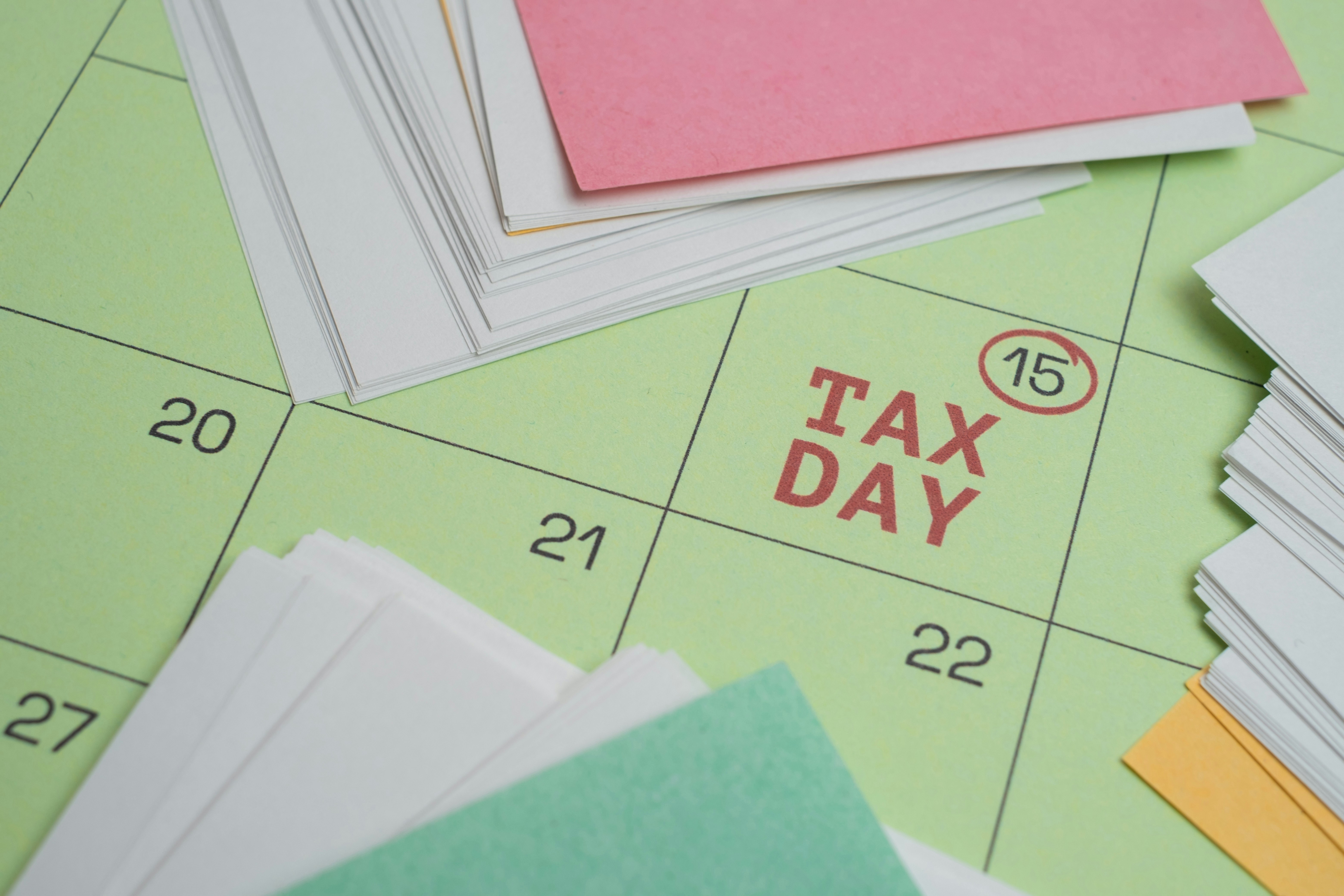 Tax day marked on a calendar with papers showing April deadline preparation