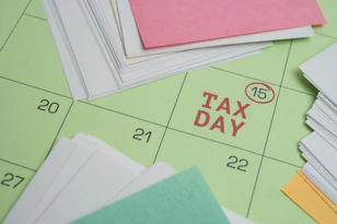 Tax day marked on a calendar with papers.