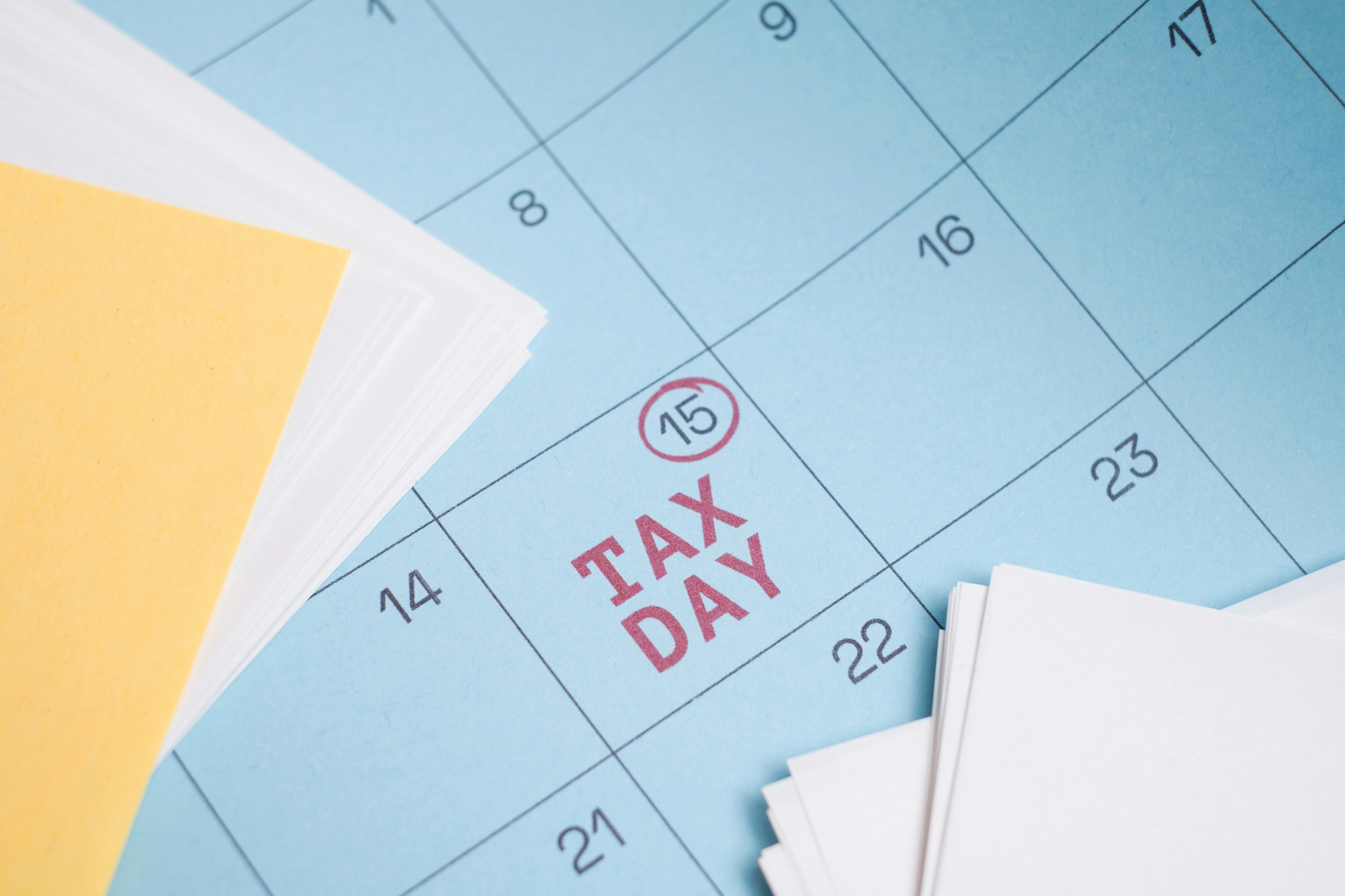 Tax Day. Blue Wall Calendar with April 15 Circled and Labeled as Tax Day Deadline. Close-up