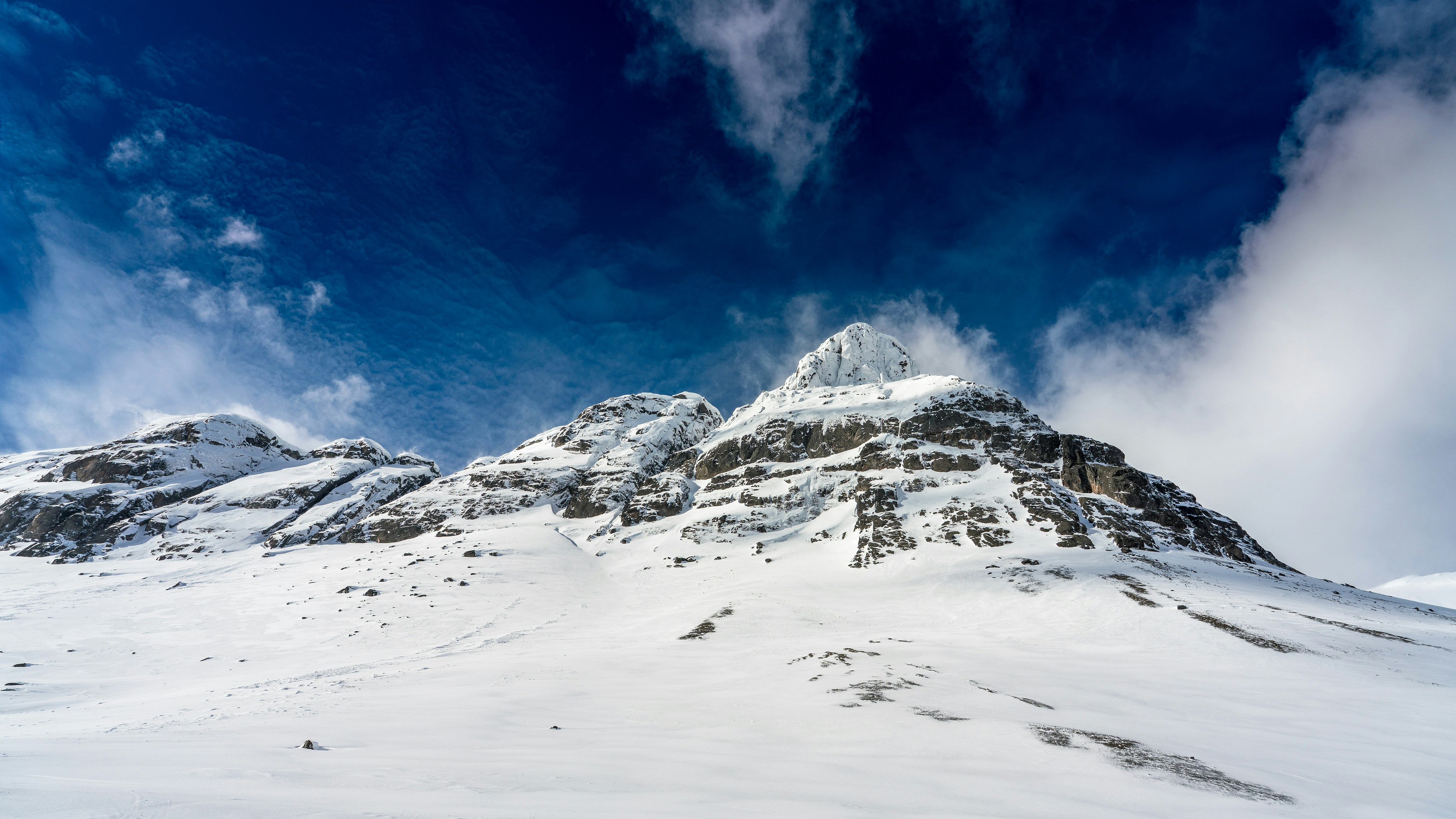 Snowy mountain peaks under a vibrant blue sky.