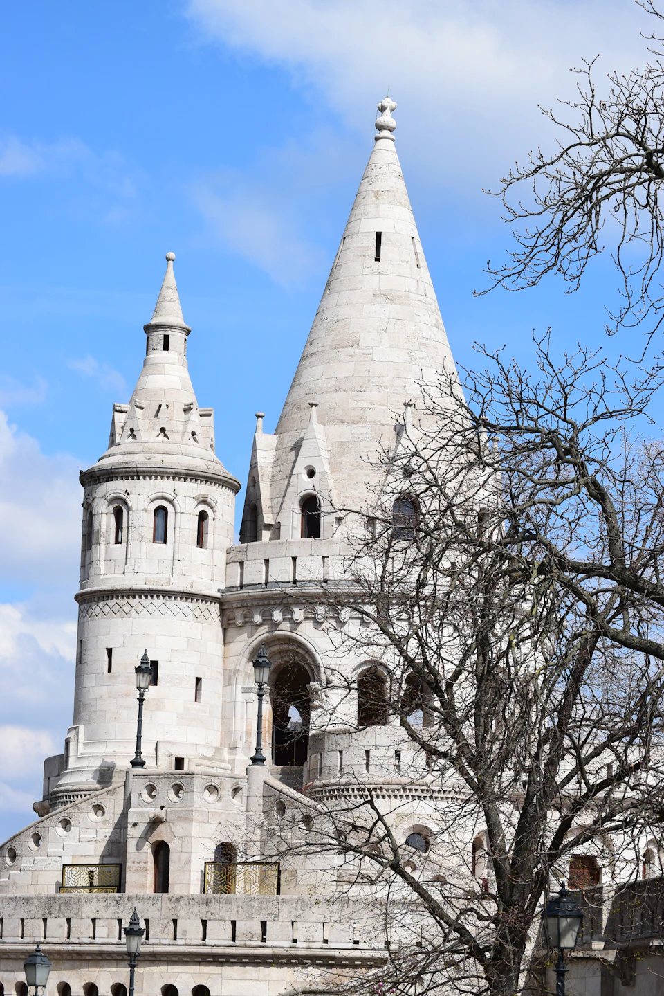 Majestic white stone castle with multiple towers and spires standing tall against clear blue sky