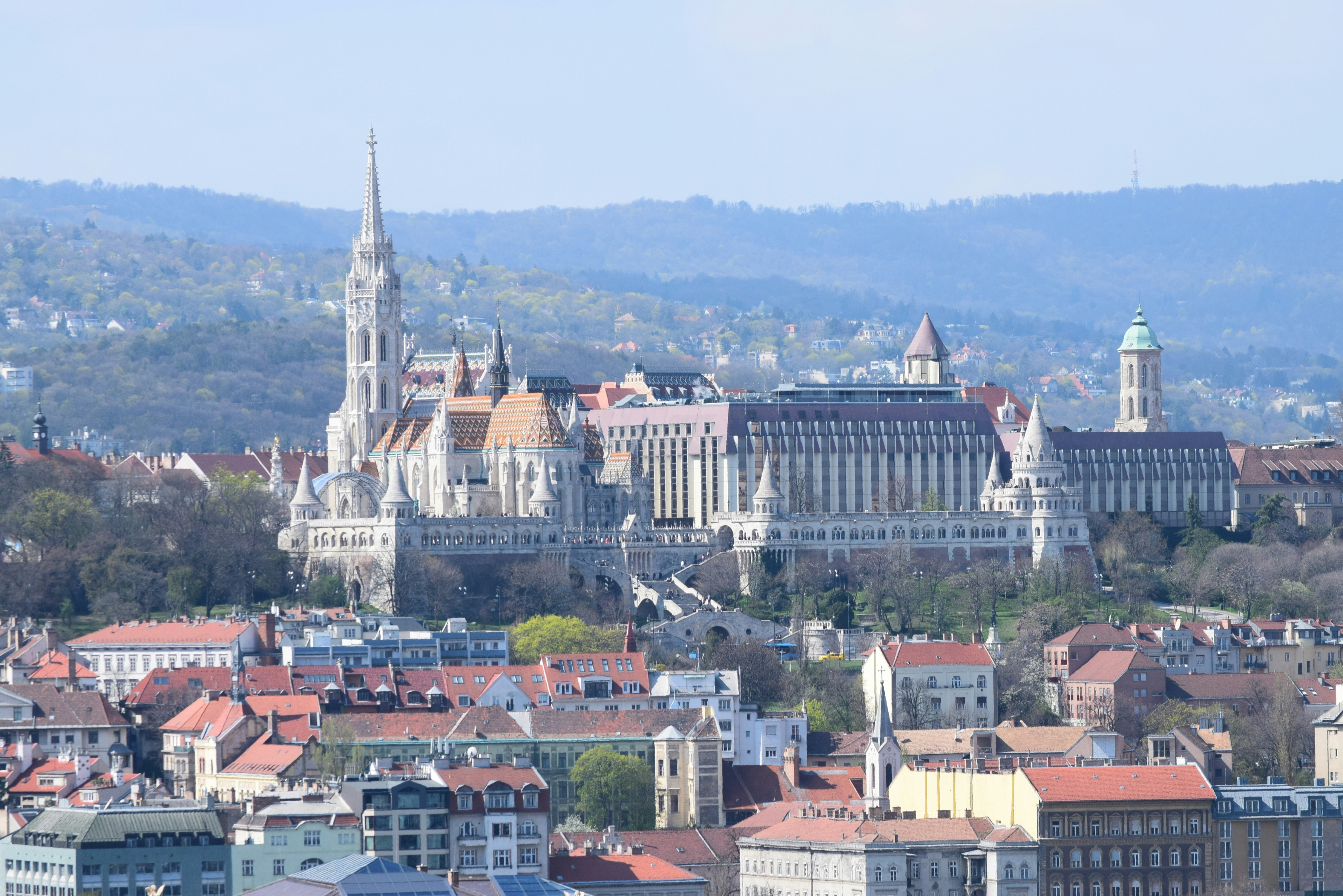 Historic buildings with spires and domes against hills