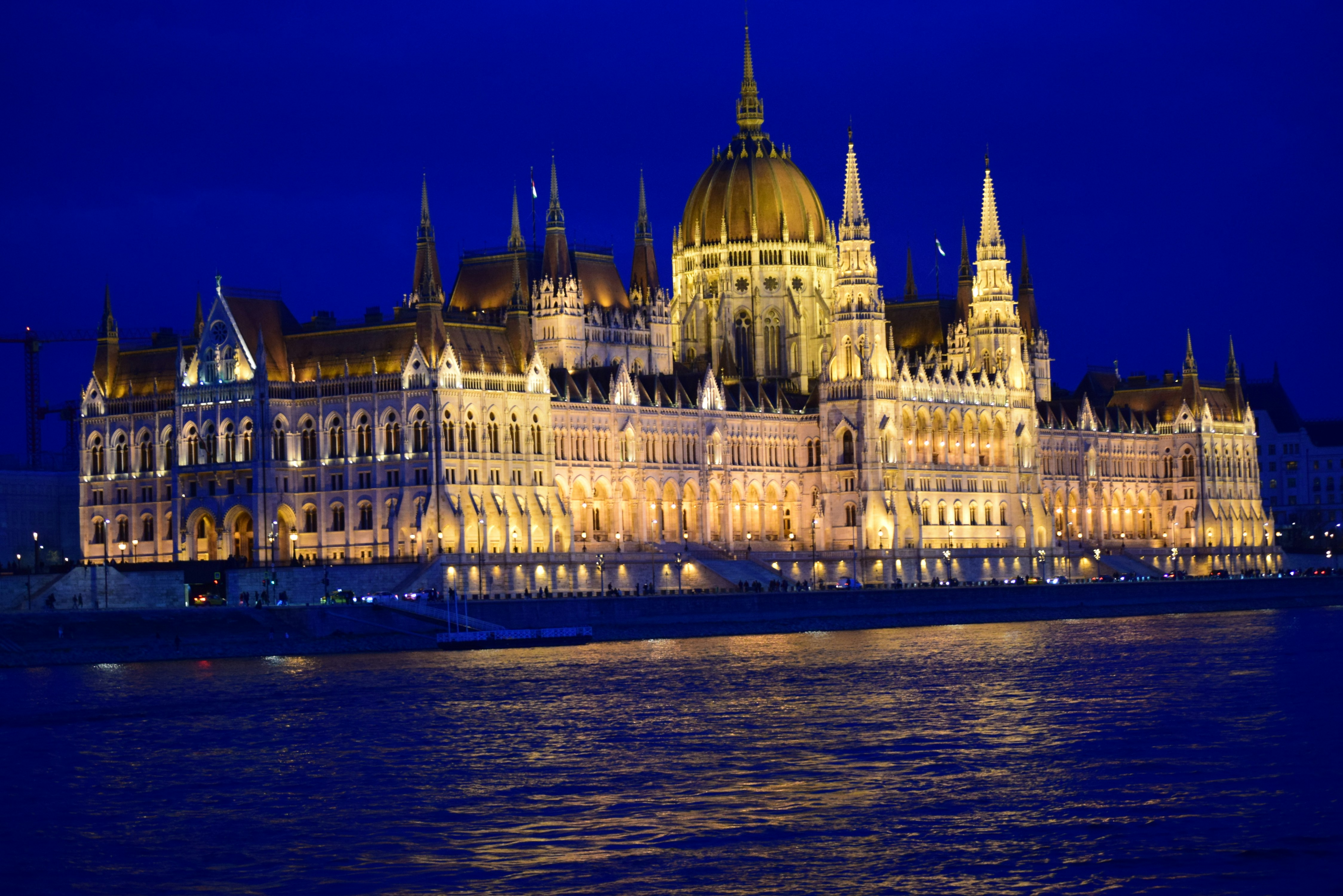 Illuminated parliament building at night by the river.