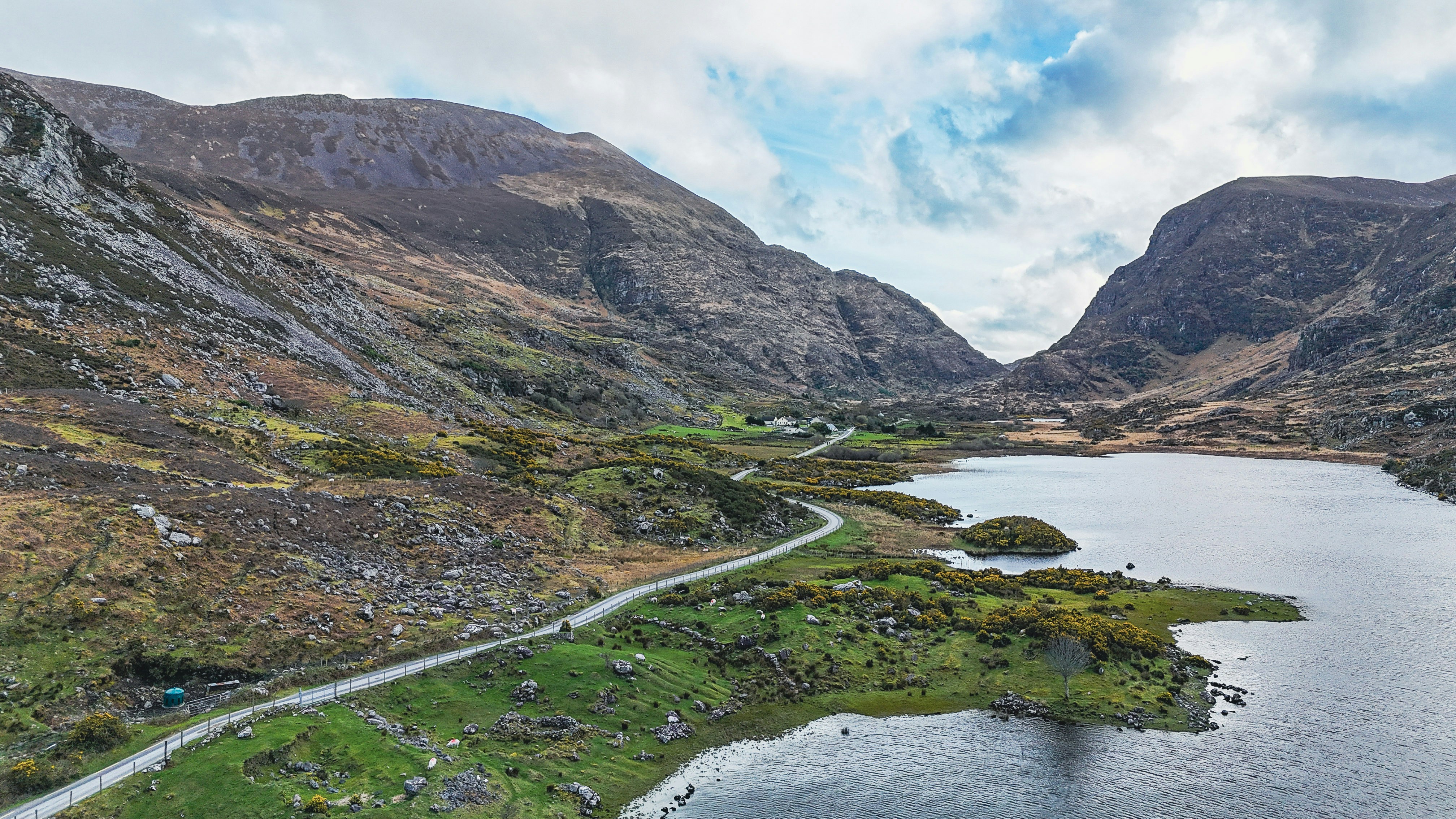 山岳の谷の湖畔を曲がりくねった道。