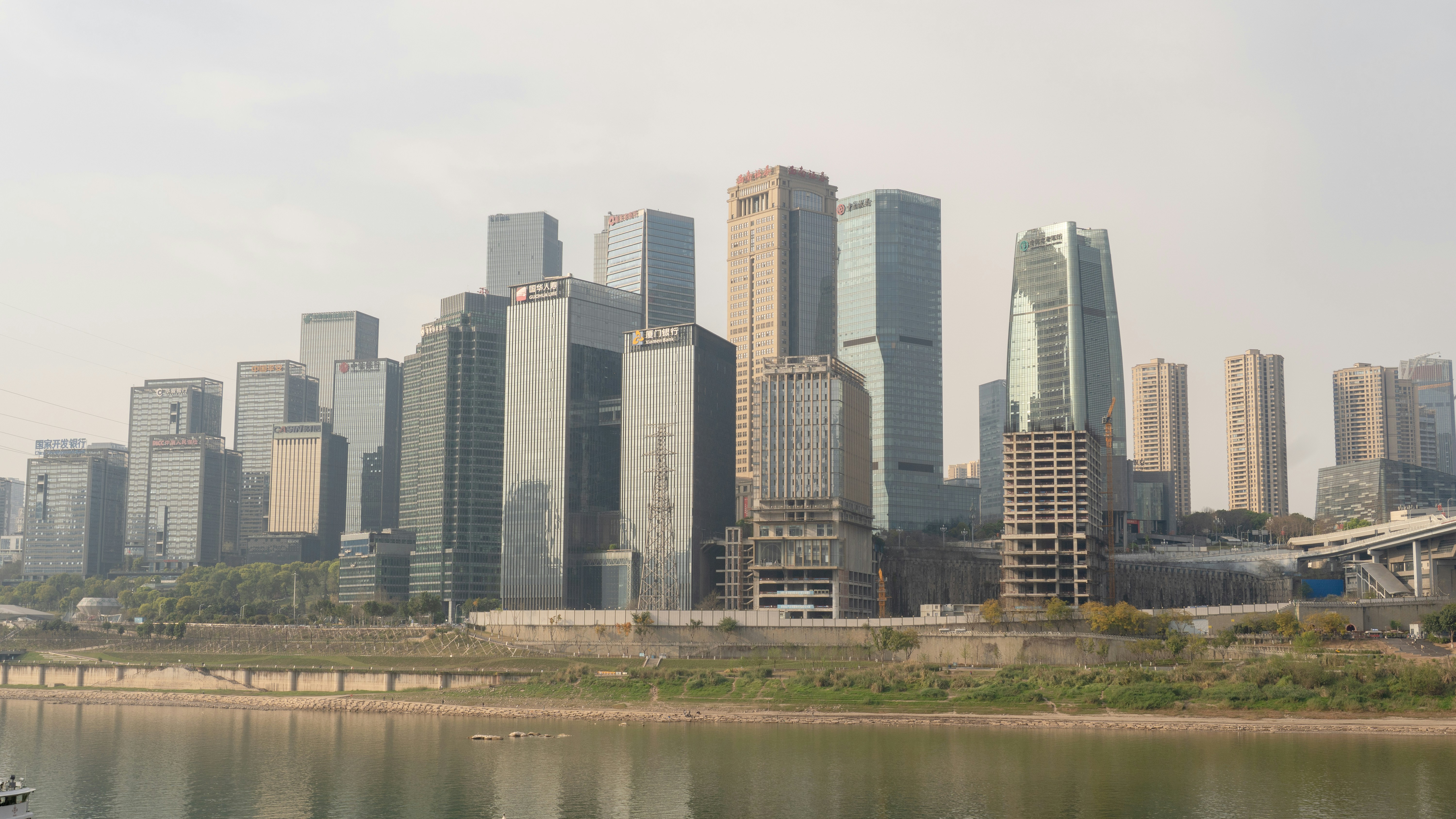 Modern skyscrapers rise above a calm river