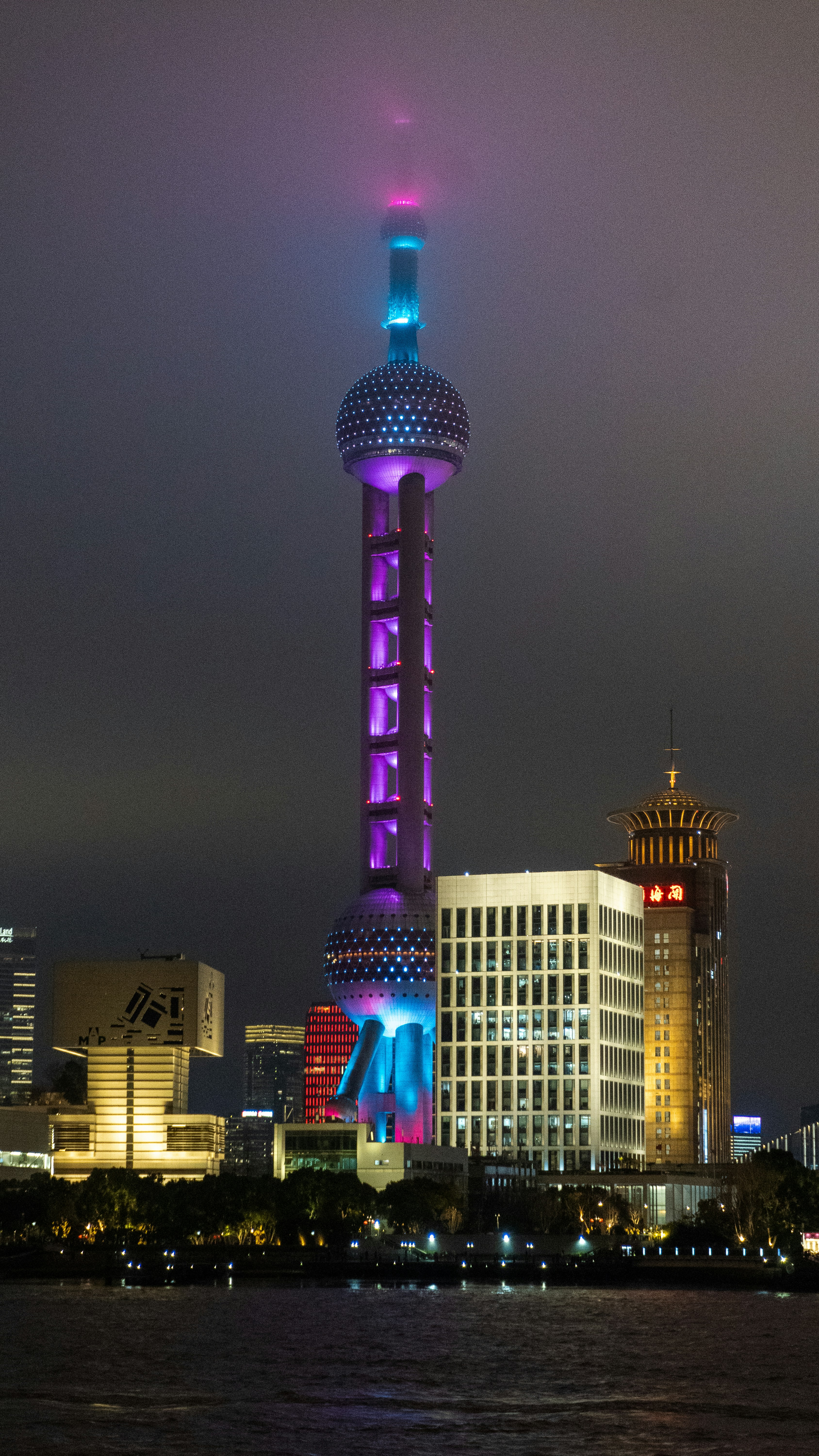 Torre di perle orientali illuminata di notte dalle luci della città.