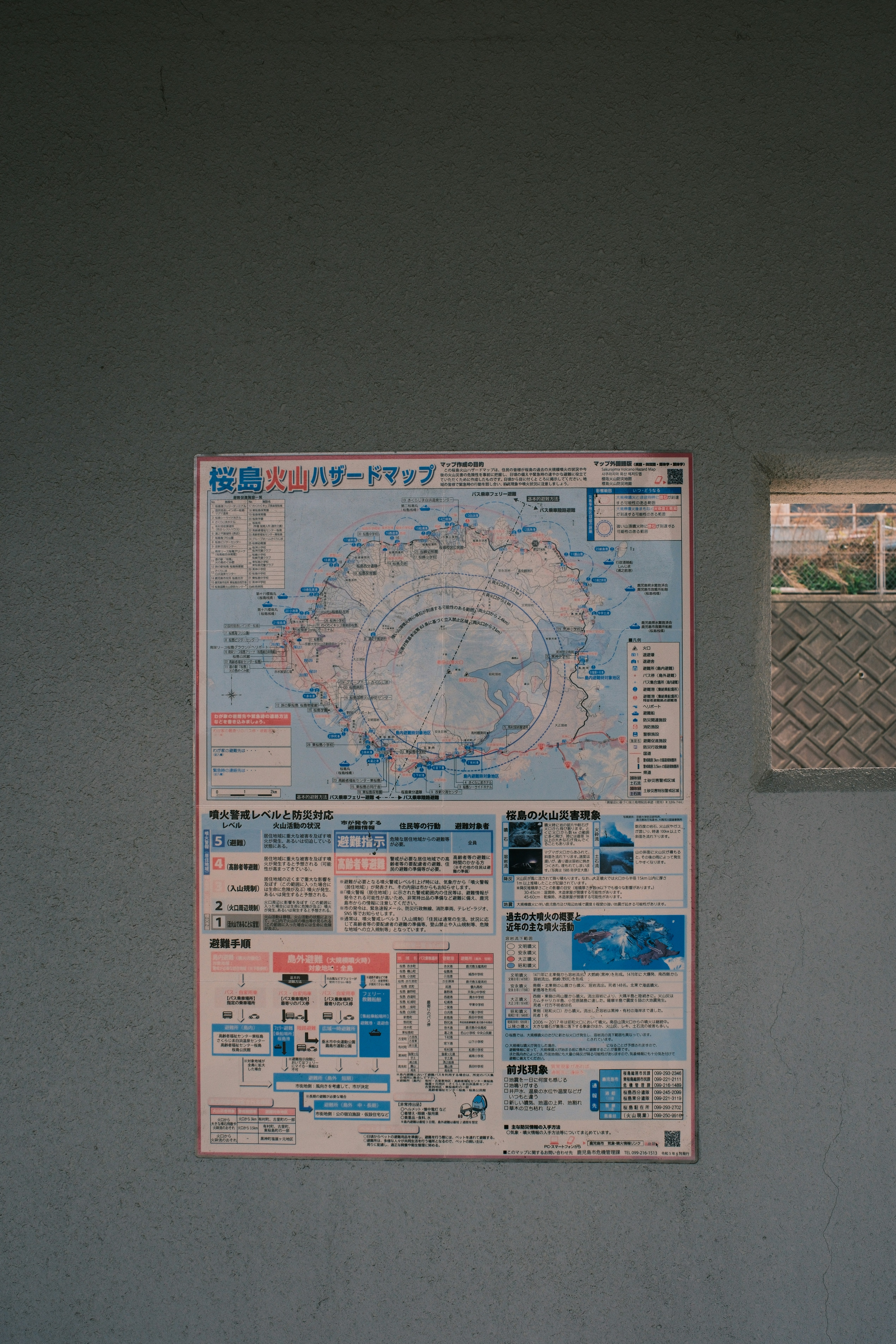 A map with japanese text hangs on a blue wall.