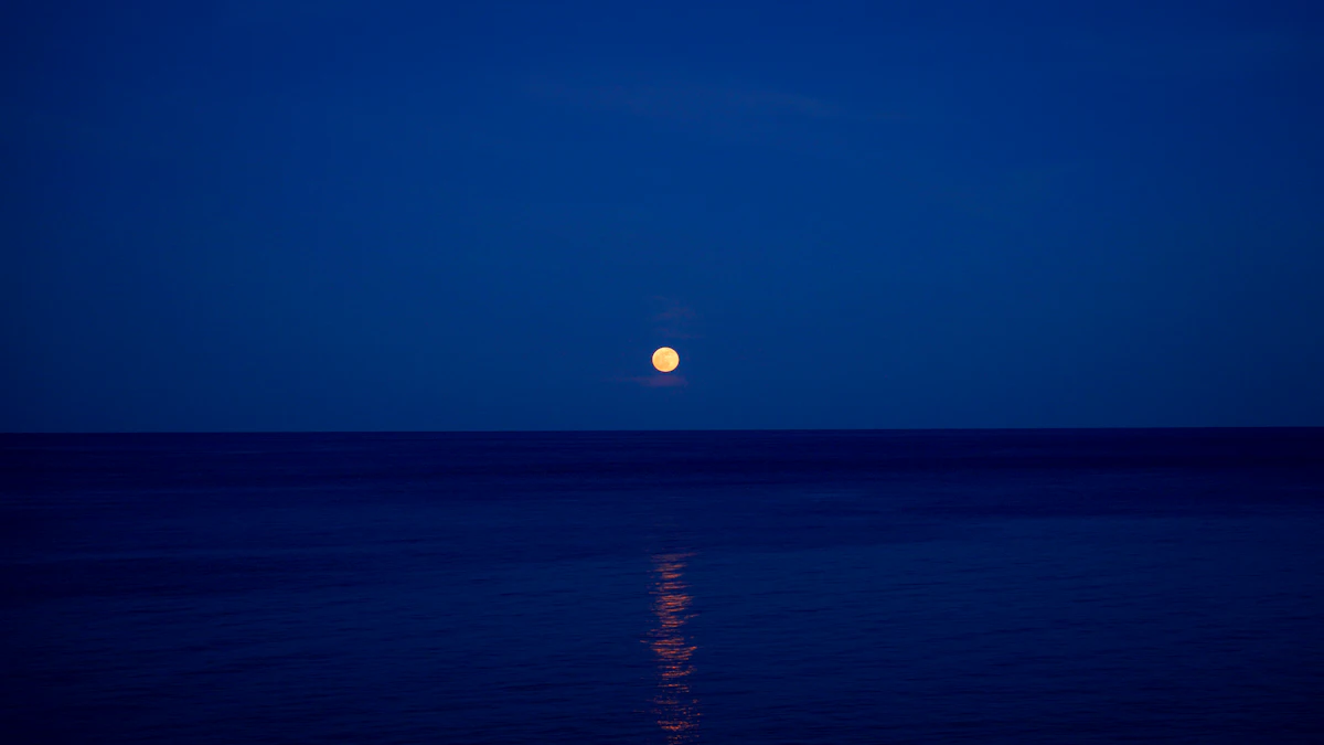 A full moon over the water on Visakha Bucha night