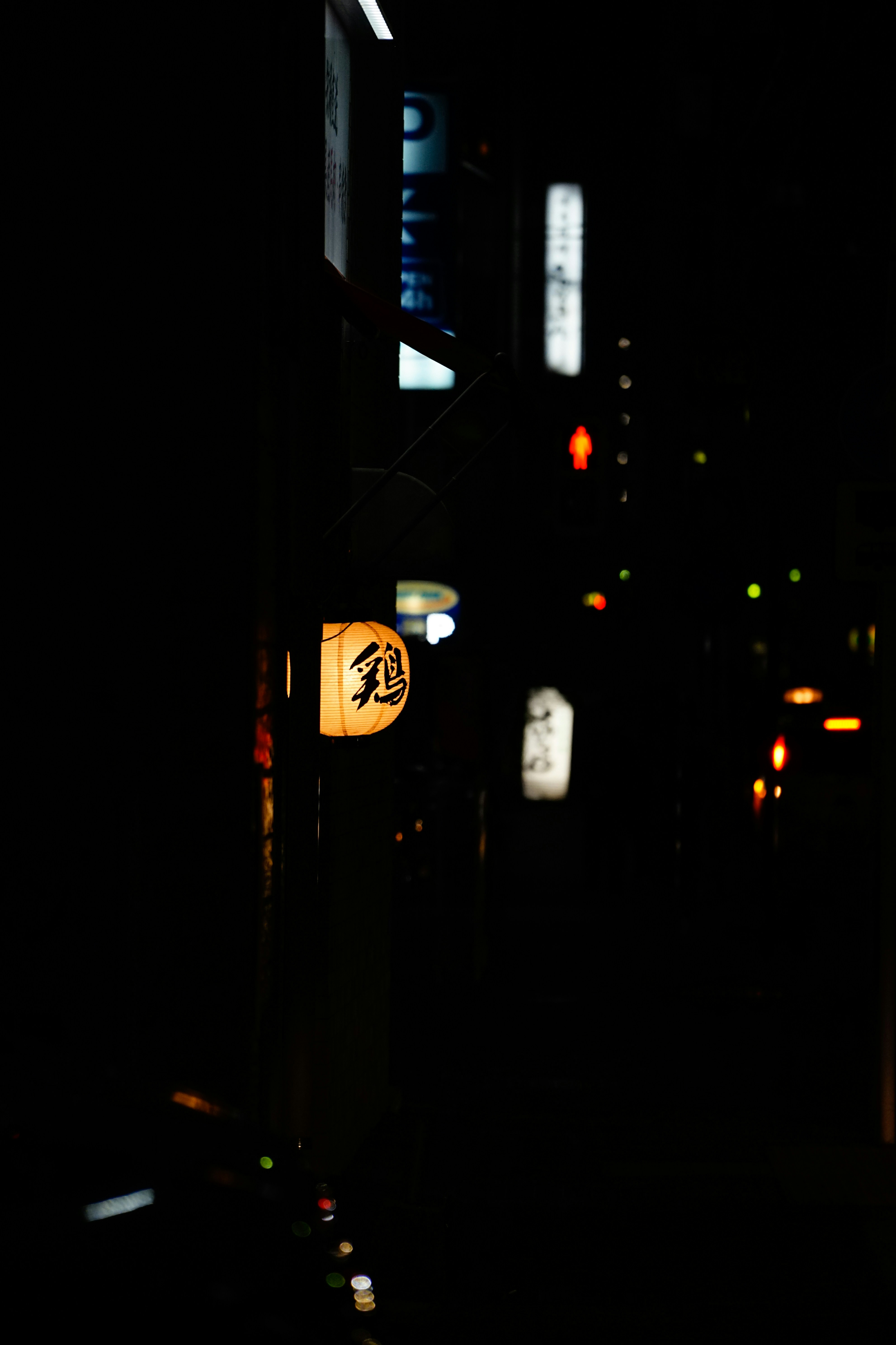 Glowing japanese lantern on a dark street at night