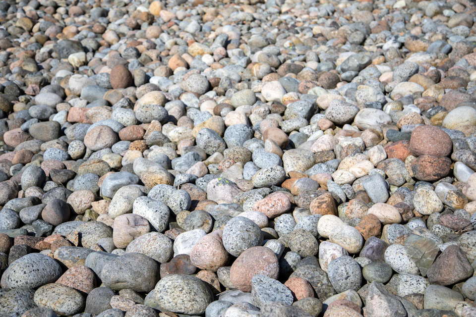 Close-up view of rocky beach with scattered small rocks in varying sizes and colors