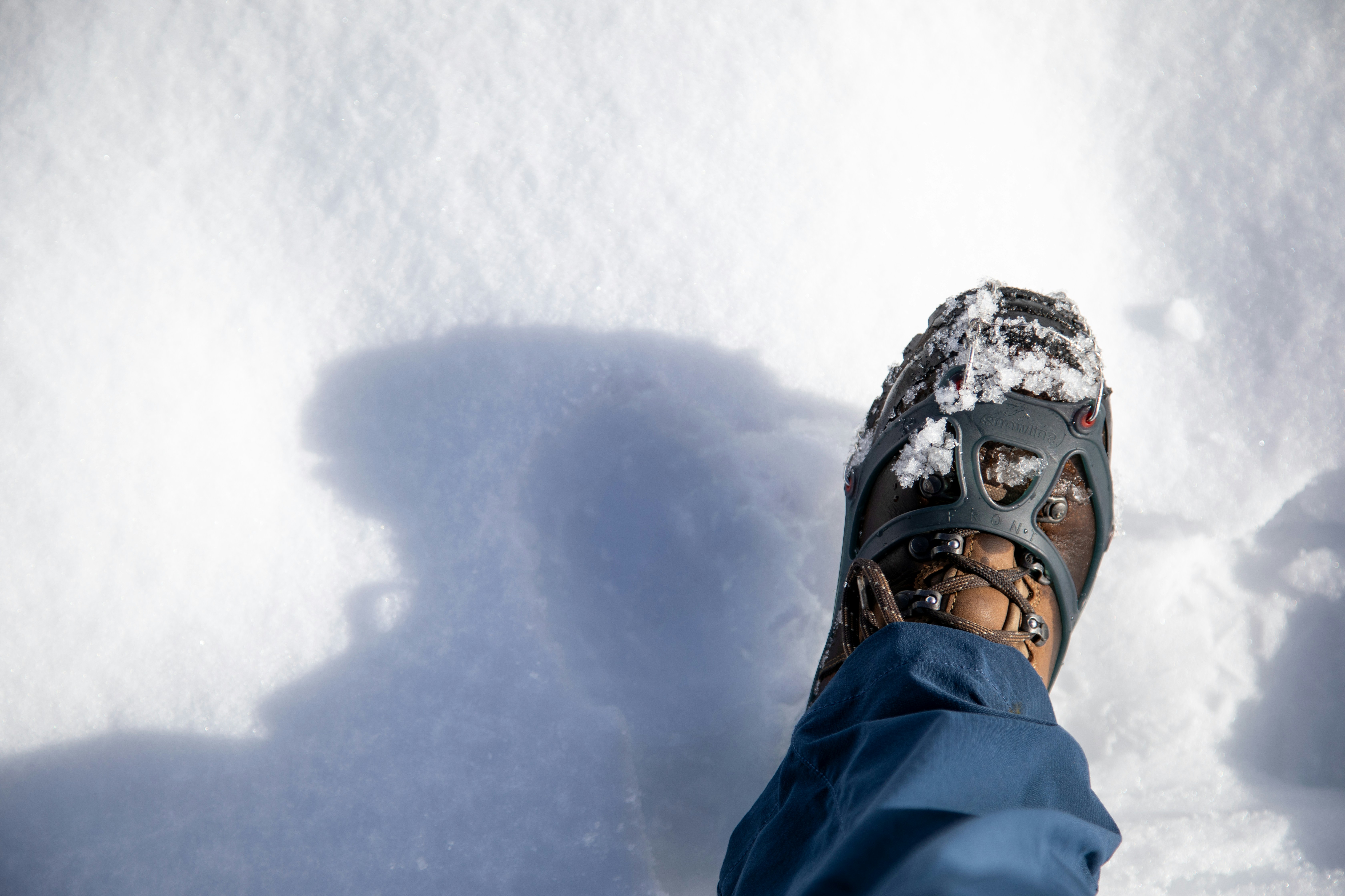 Uno stivale con i ramponi camminando sulla neve