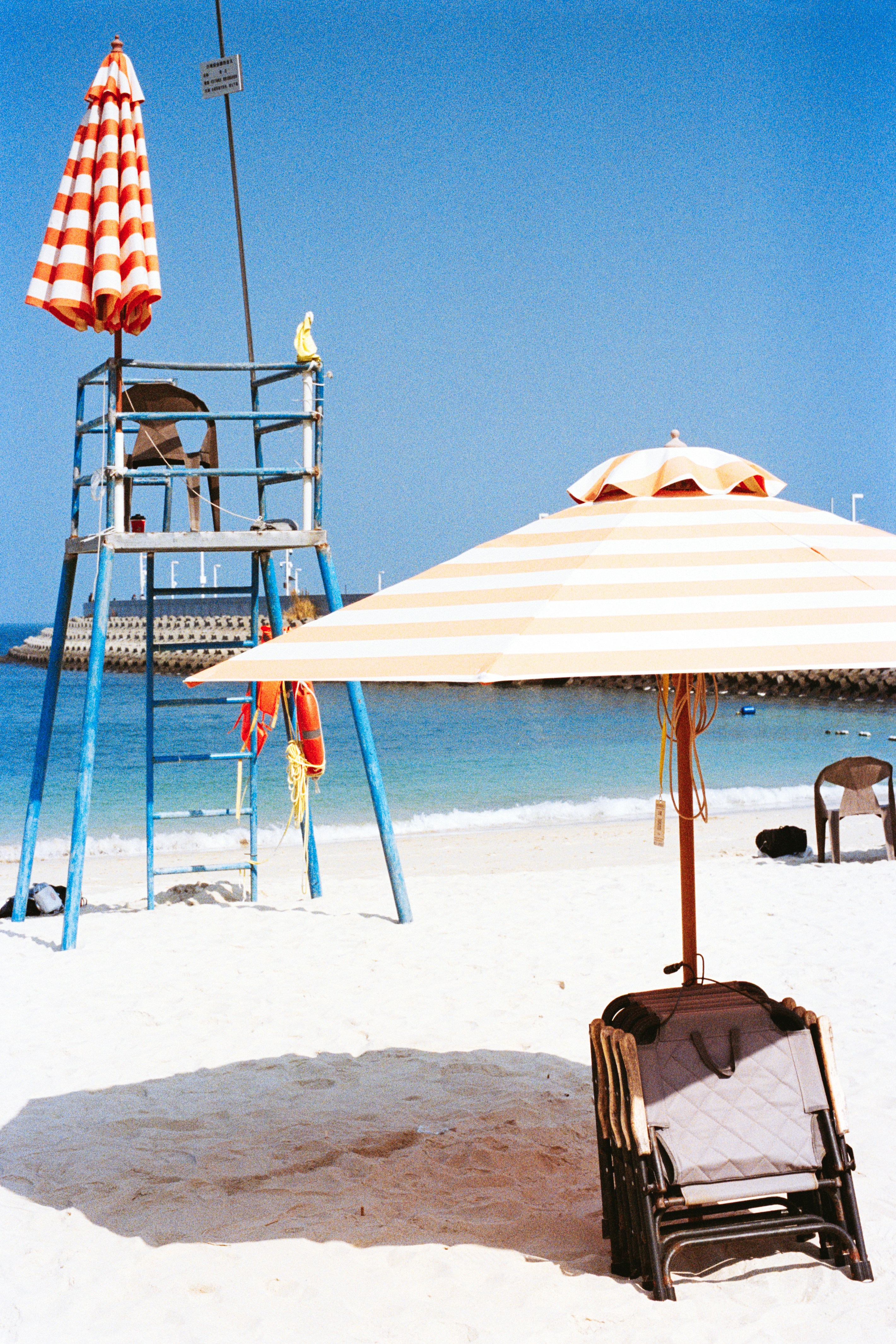 Beach scene with lifeguard stand and umbrellas